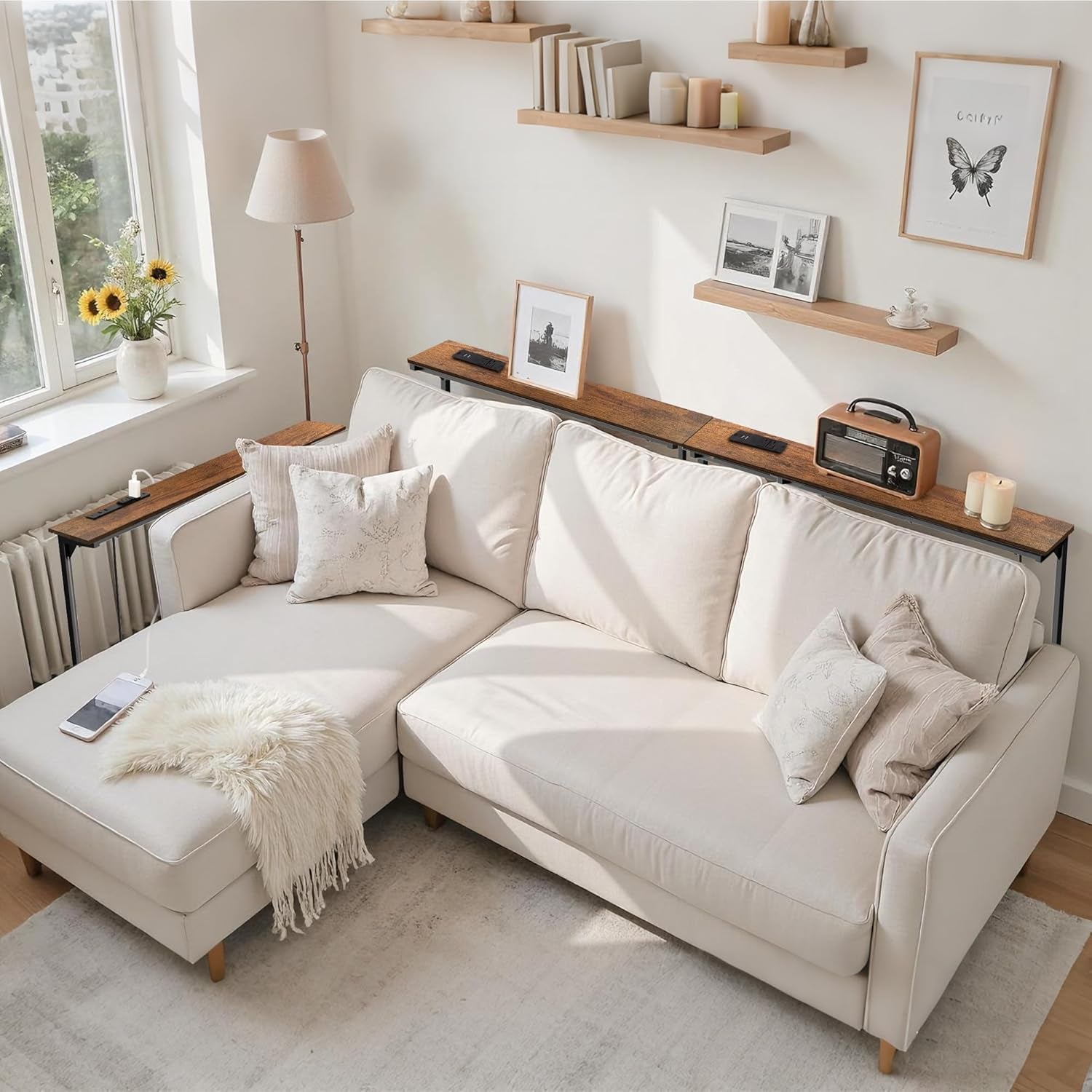 Two brown console tables form an L behind a white sectional, with inset power panels on both tops.