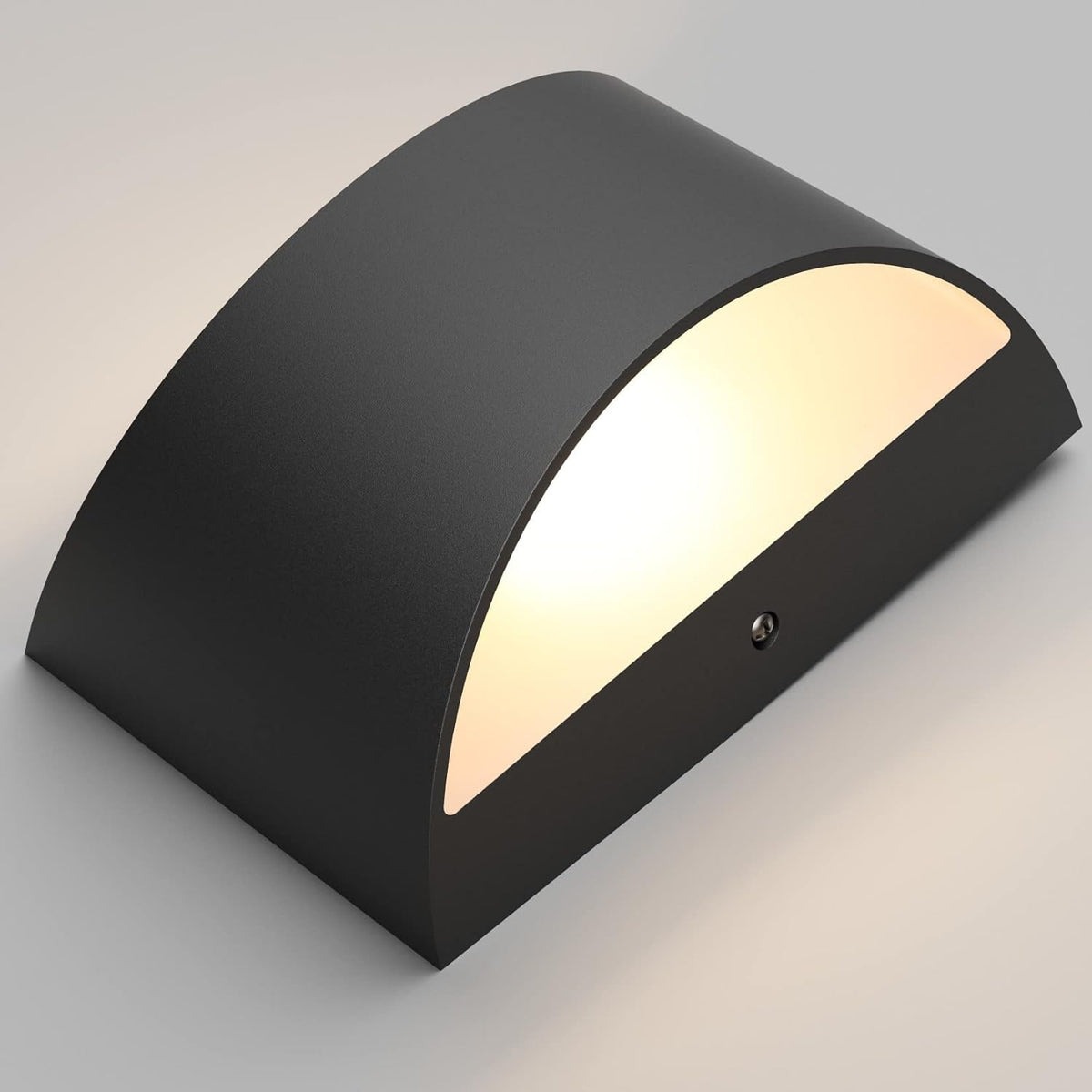 Close angled view of the black sconce showing its curved top and lit interior opening