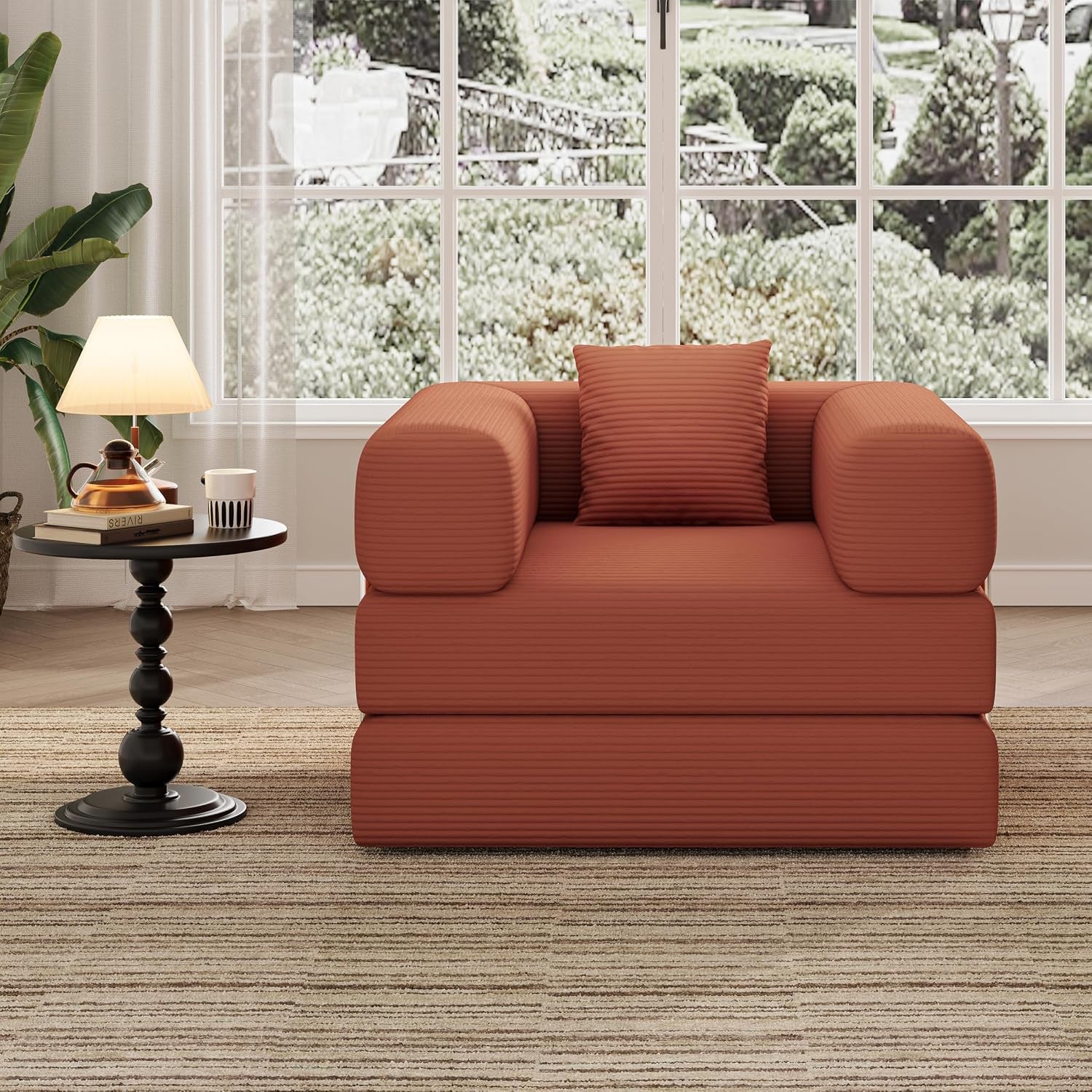 Front view of a rust-colored corduroy single seat floor sofa with square pillow in a bright room