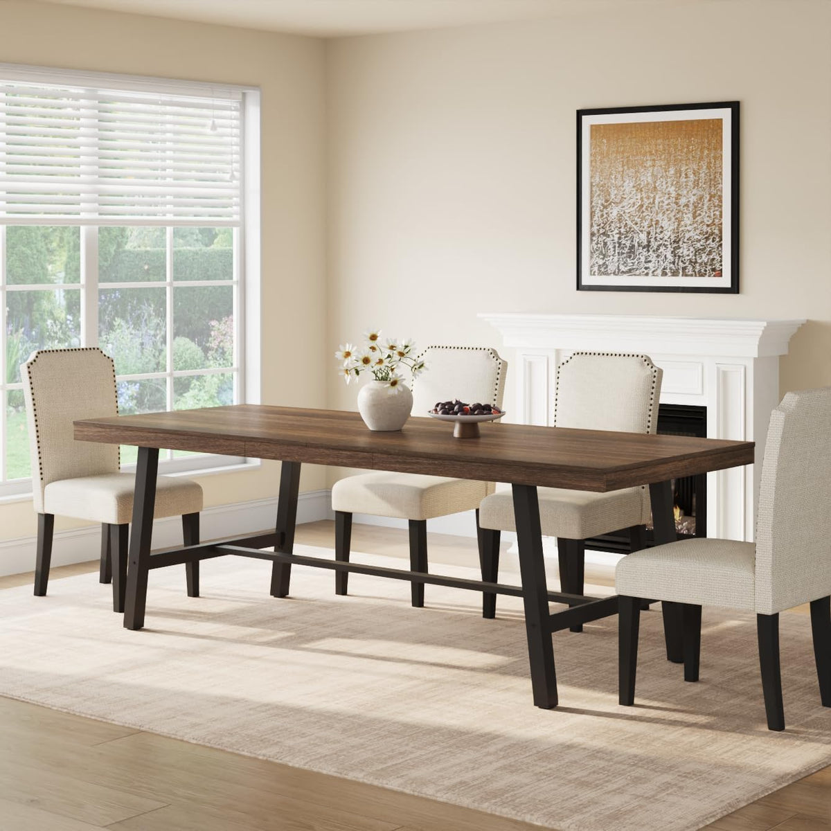 Dark wood rectangular table with angled black metal legs surrounded by light fabric chairs near a fireplace