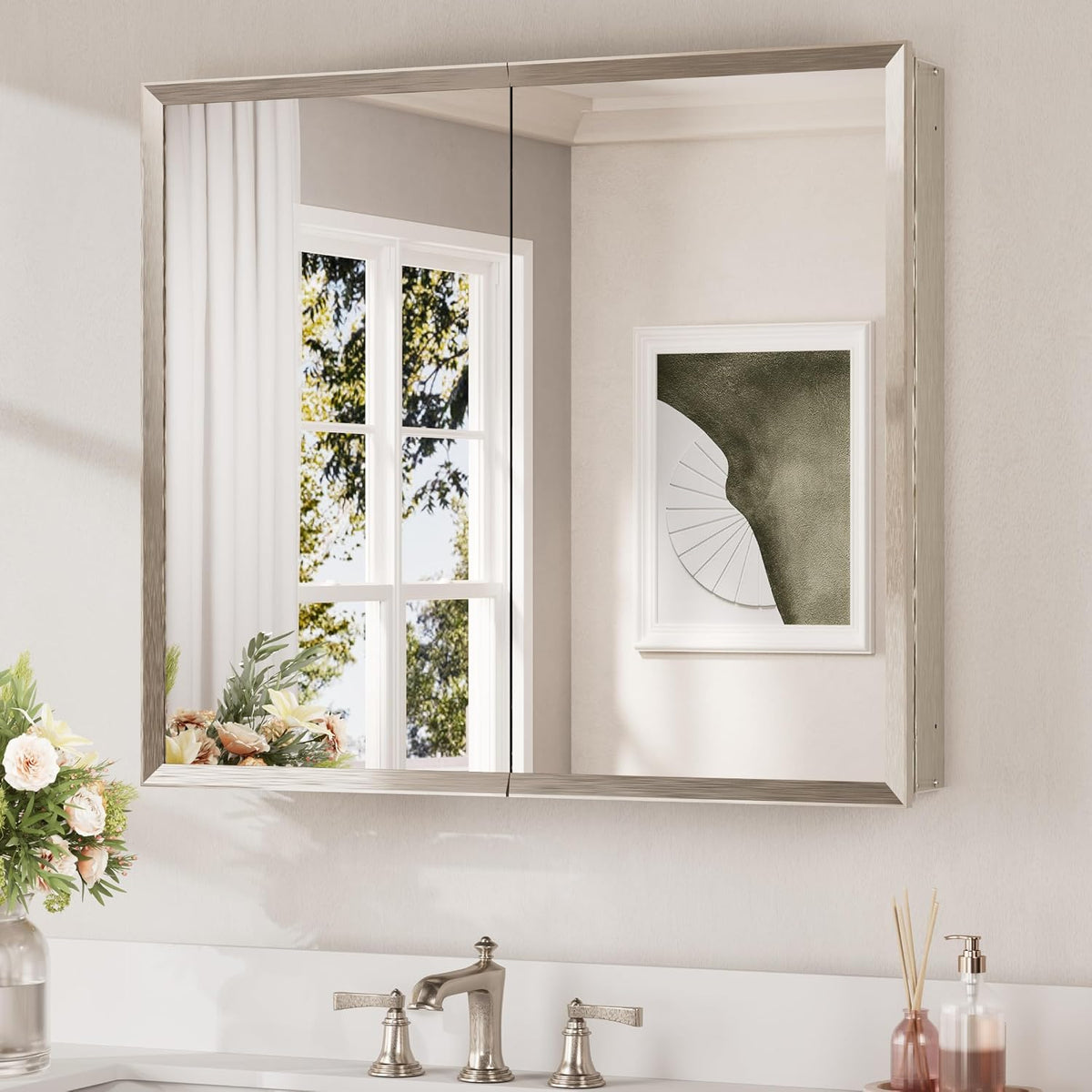 Wall-mounted two-door mirrored medicine cabinet with brushed silver frame above a sink