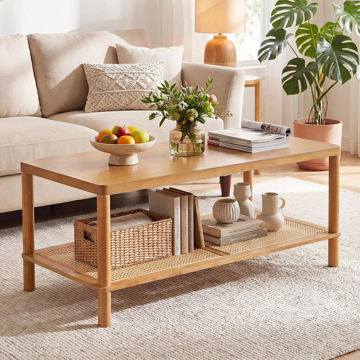 Light natural wood rectangular coffee table with woven lower shelf styled with books and vases