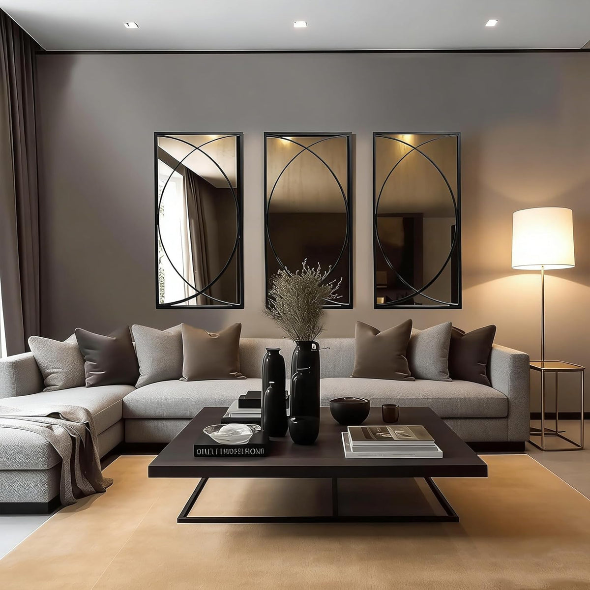 Three slim black-framed rectangular mirrors with circular overlay hung above a light gray sectional sofa in a modern living 룸