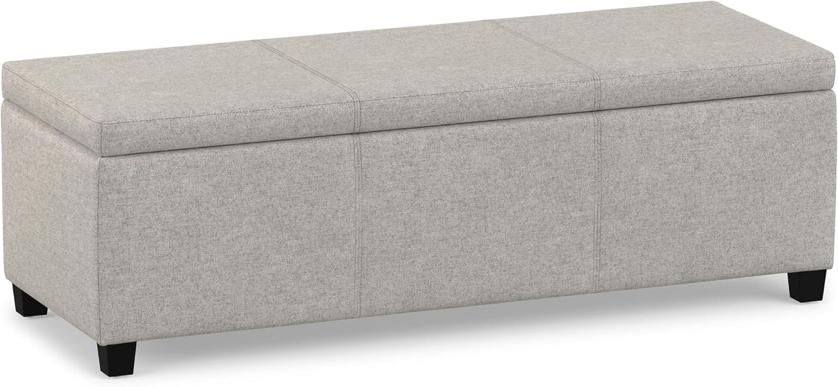 Three-quarter front view of a light grey rectangular lift-top storage ottoman on short black legs.