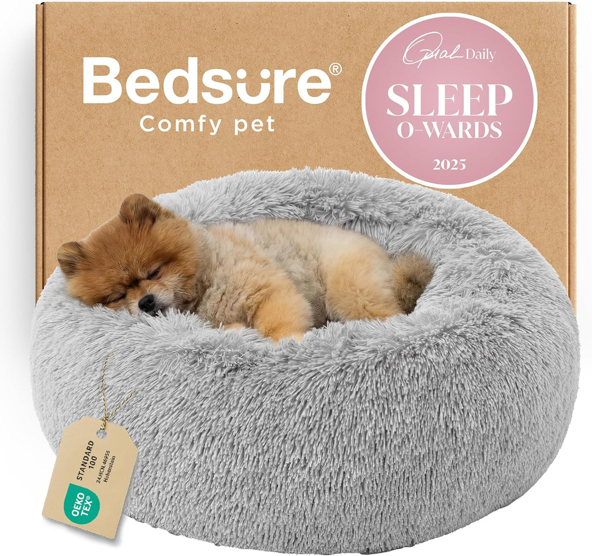 Light gray round faux-fur donut bed with a tiny fluffy tan puppy curled up and sleeping.