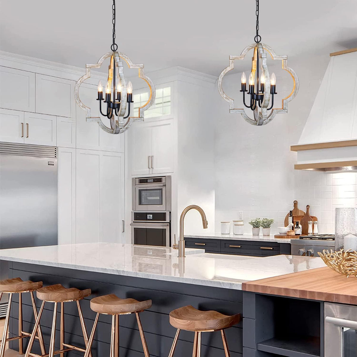 Two wood-finish orb chandeliers suspended over a kitchen island in a bright white kitchen