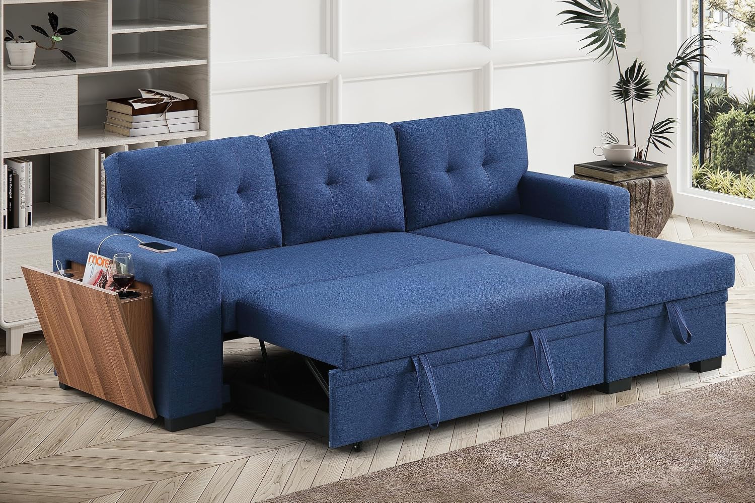 Blue L-shaped sectional sofa unfolded into a sleeper with storage pocket and wooden side tray