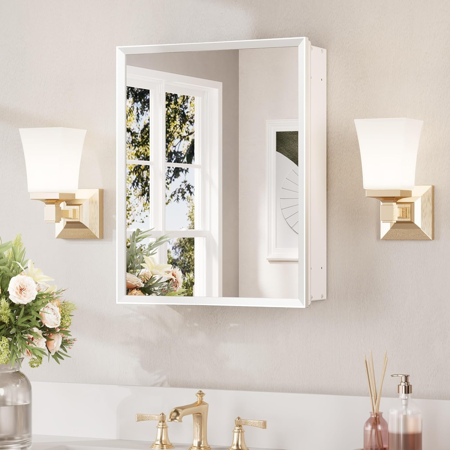 White-framed wall mirror cabinet centered between two wall sconces above a vanity.