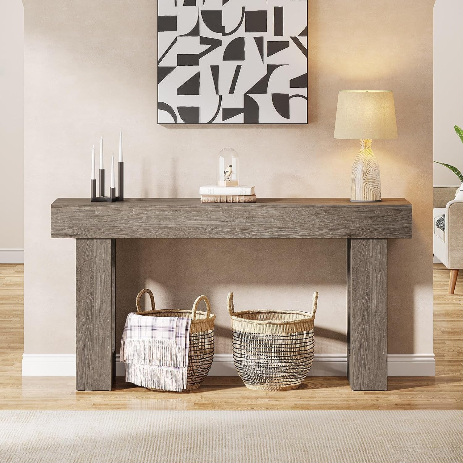 Front view of grey farmhouse console table with two woven baskets positioned underneath in an entryway