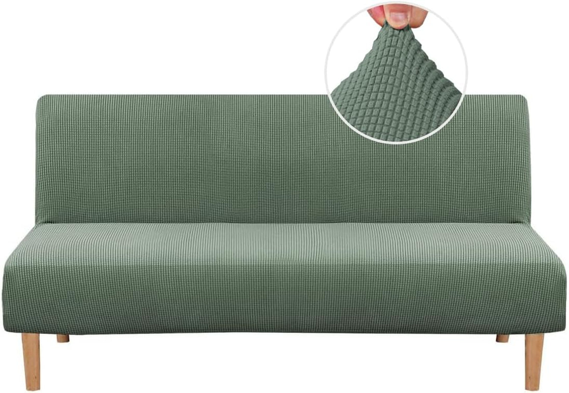 Futon covered in a light sage-green small-check slipcover, shown front-on with wooden legs and circular fabric texture