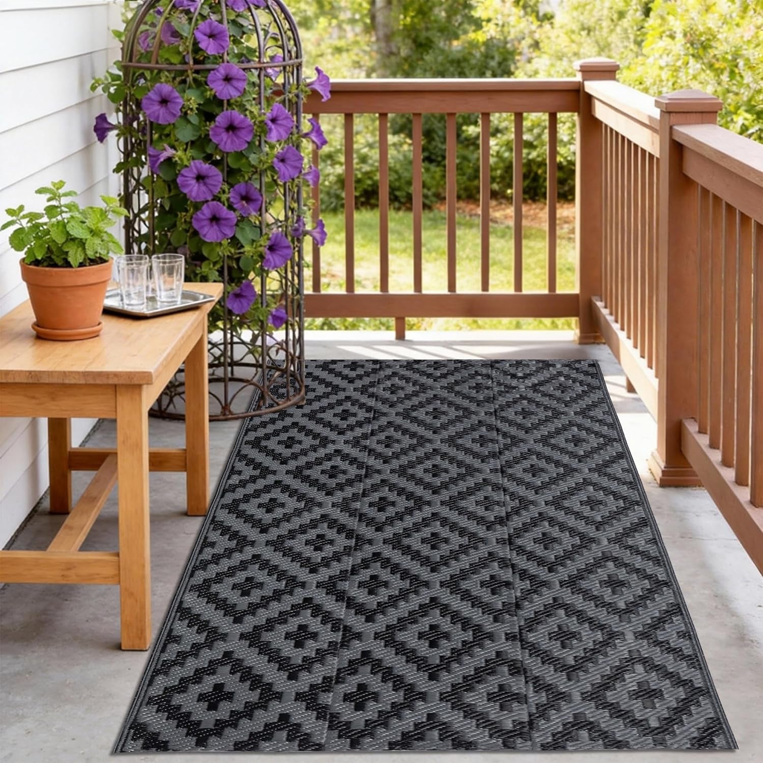 Narrow porch with railing, a bench and a dark charcoal patterned runner rug.
