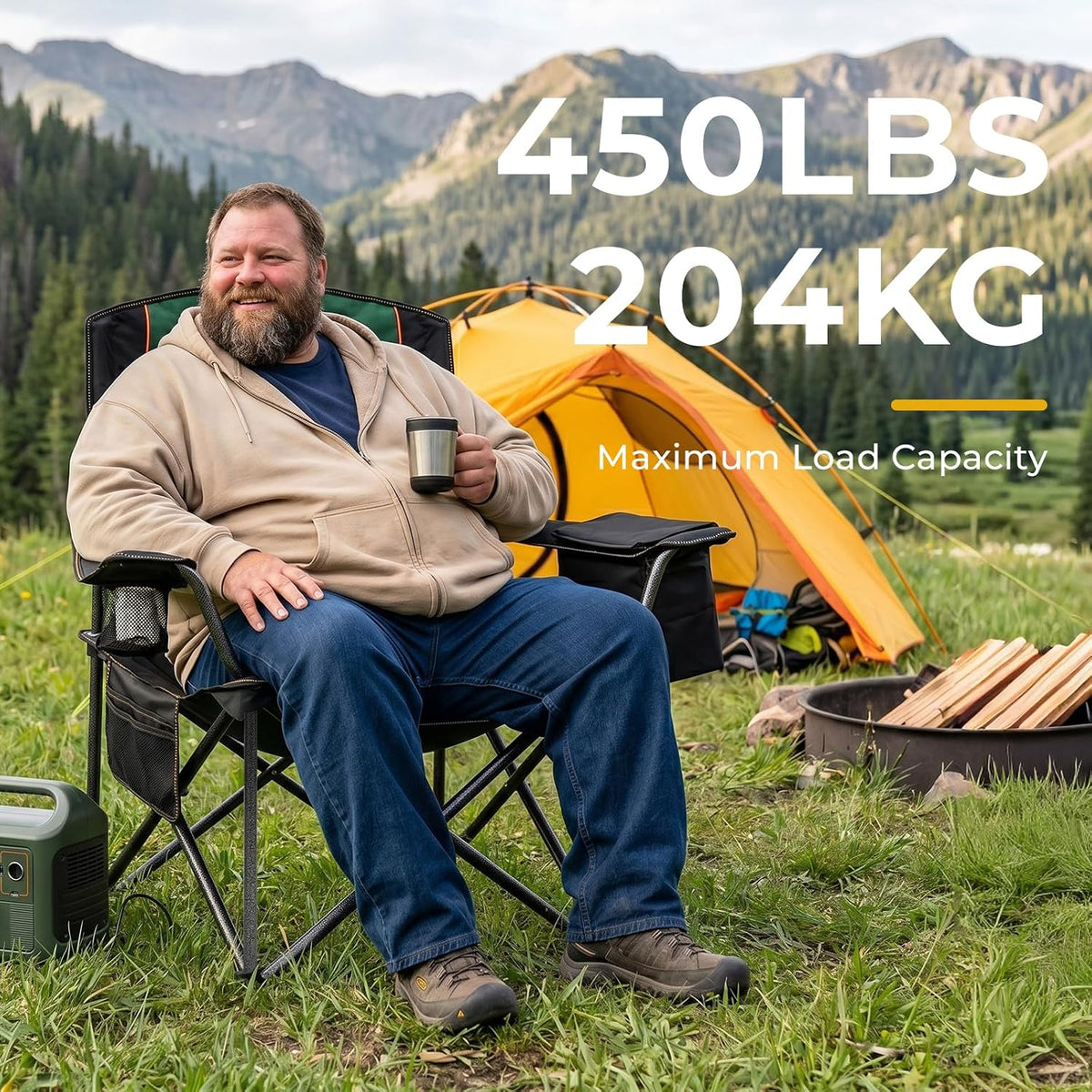 Bearded man sitting in a padded folding camping chair in front of a yellow tent and mountain background