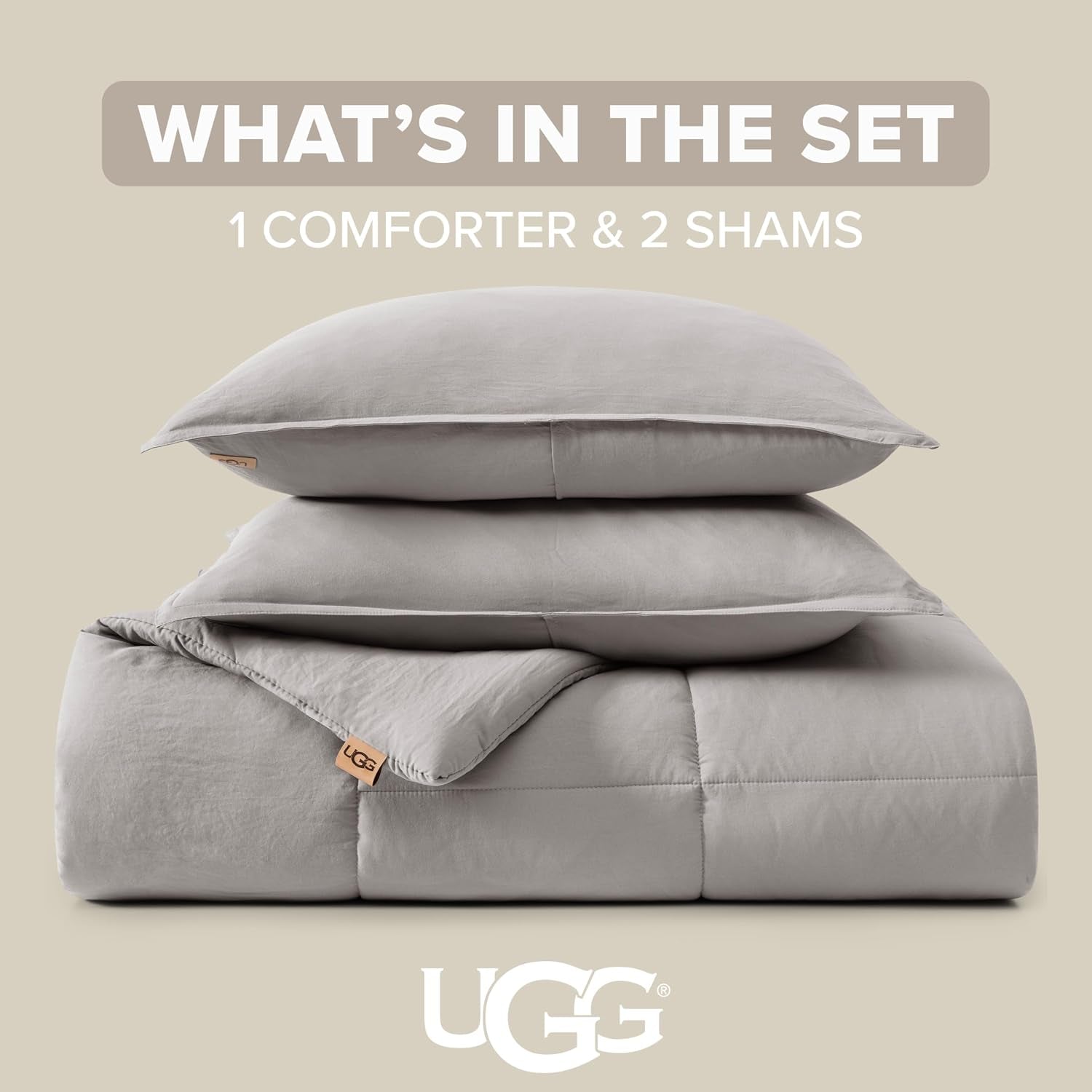 Stacked light grey comforter and two shams on a neutral background showing the folded set and fabric tag