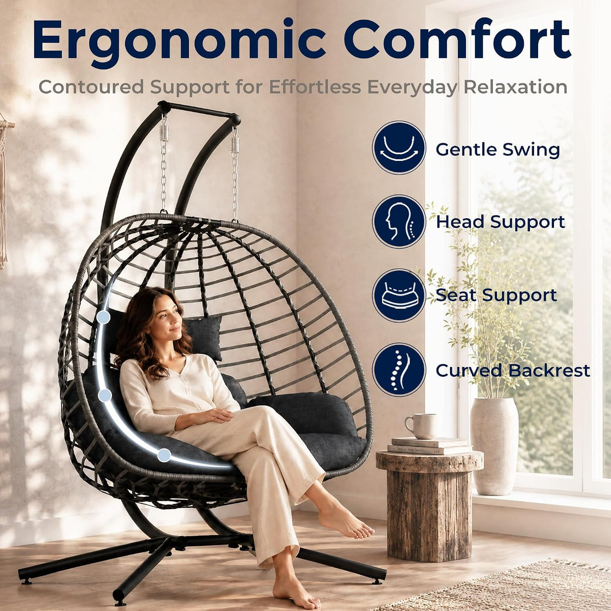 Dark gray egg swing chair in a bright room with a woman seated, highlighting curved backrest and gentle swing