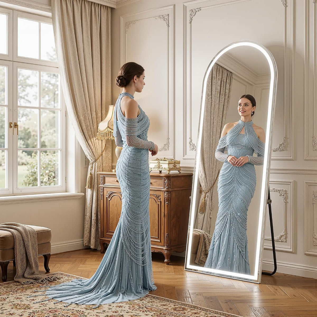 Woman in a blue evening gown standing in front of a leaning arched LED full-length mirror showing her reflection