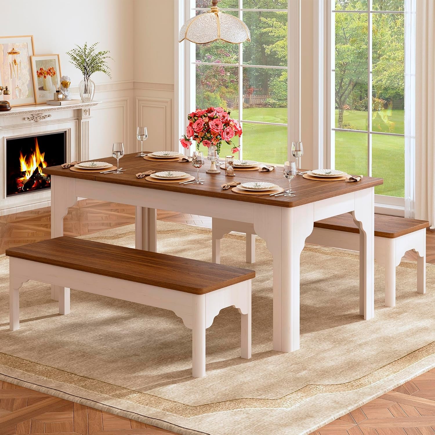 Brown wood-top farmhouse dining table with white base and two benches in a bright dining room, angled front view.