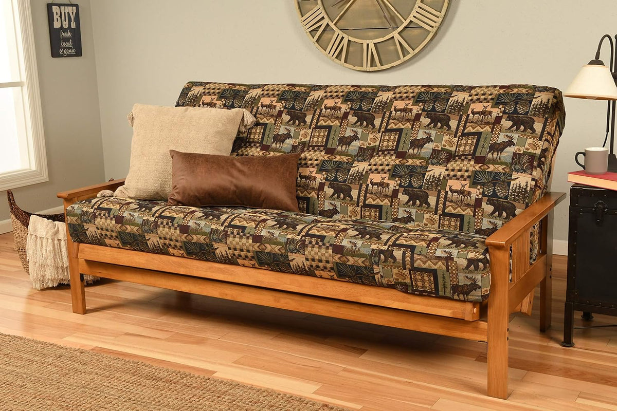 Full futon with darker patchwork wildlife print upholstery on a honey-toned wooden frame, no throw pillows.