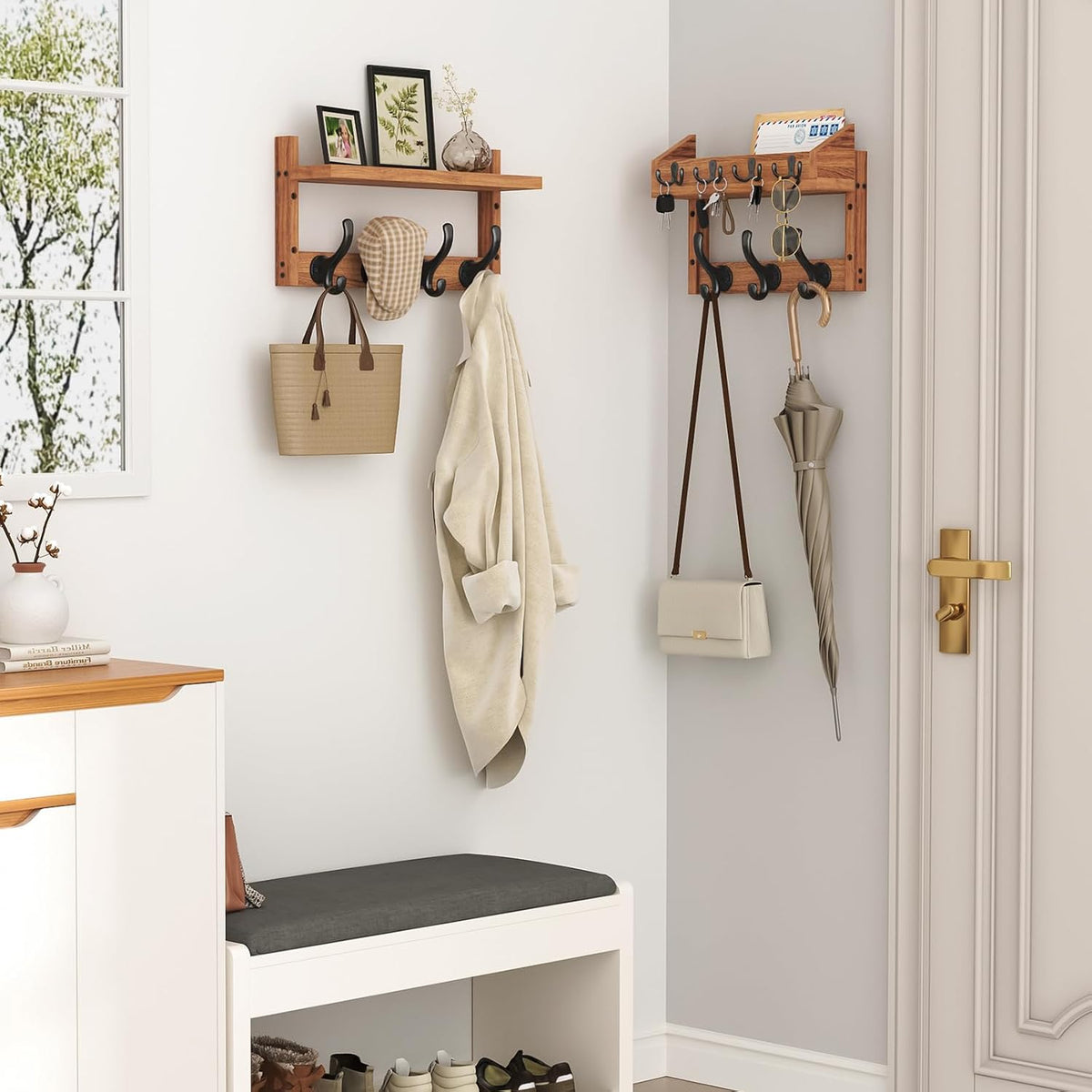 Two mounted wooden racks in an entryway holding a bag, umbrella, hat and coat next to a bench and door