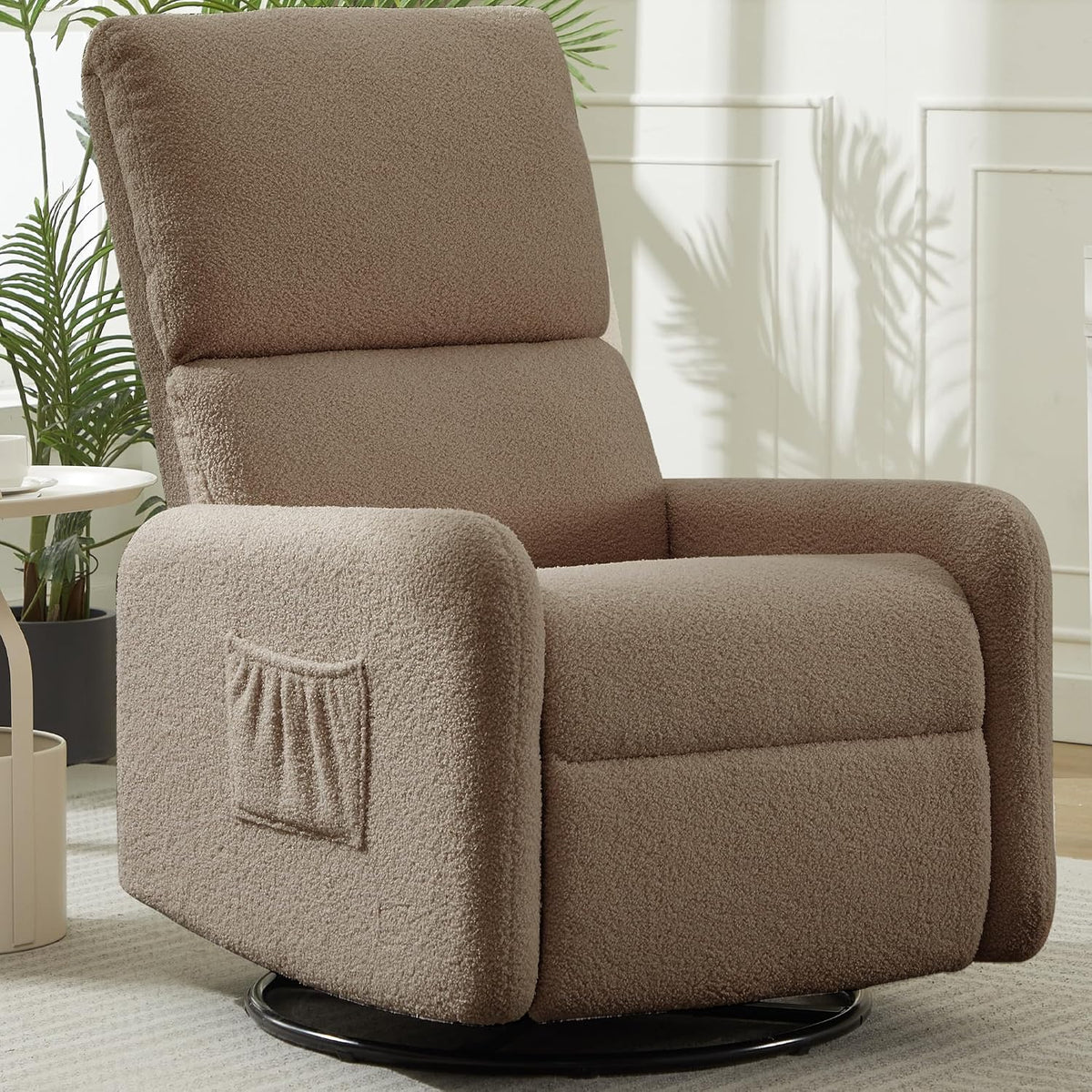 Taupe sherpa swivel rocker shown three-quarter front with rounded arms, side pocket and black circular base.