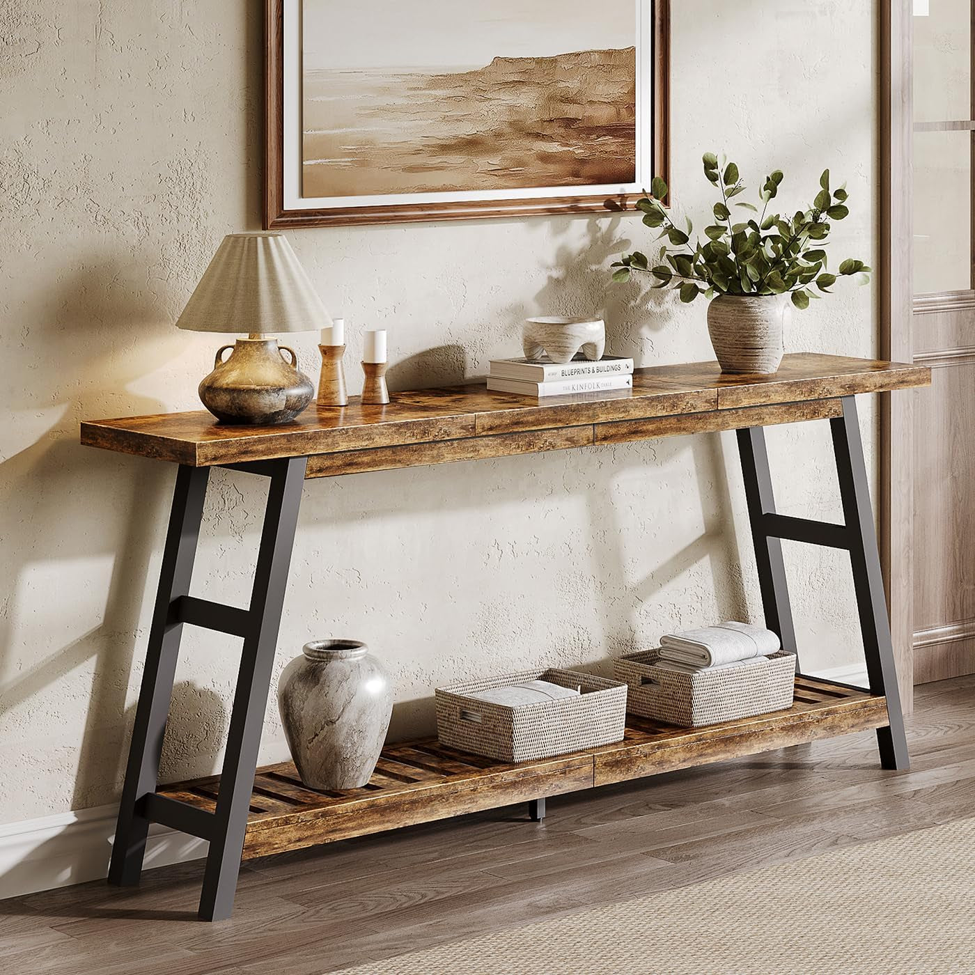 Console table styled in a living space with darker legs, tabletop decor, slatted shelf with baskets and a ceramic urn.