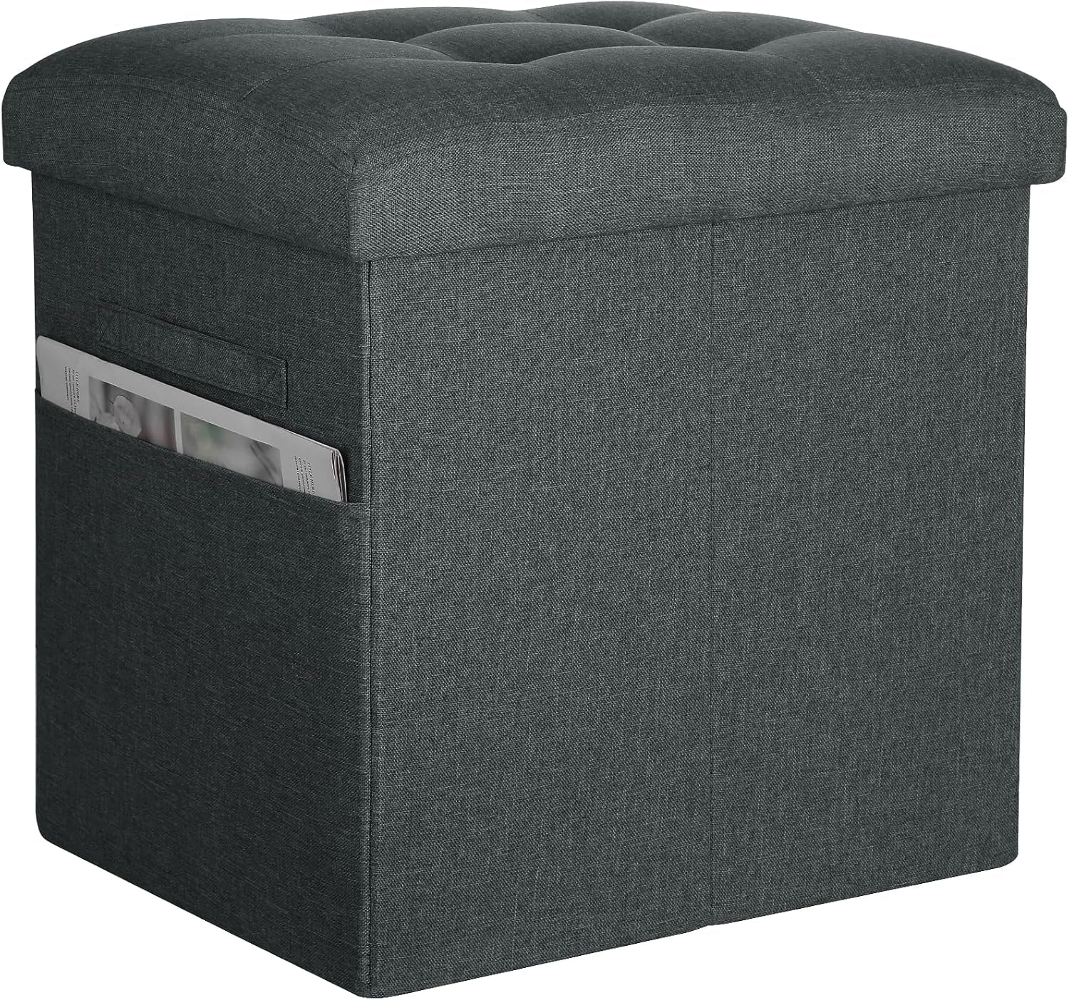 Dark gray linen-look storage ottoman with thick tufted top and side pocket containing a folded magazine
