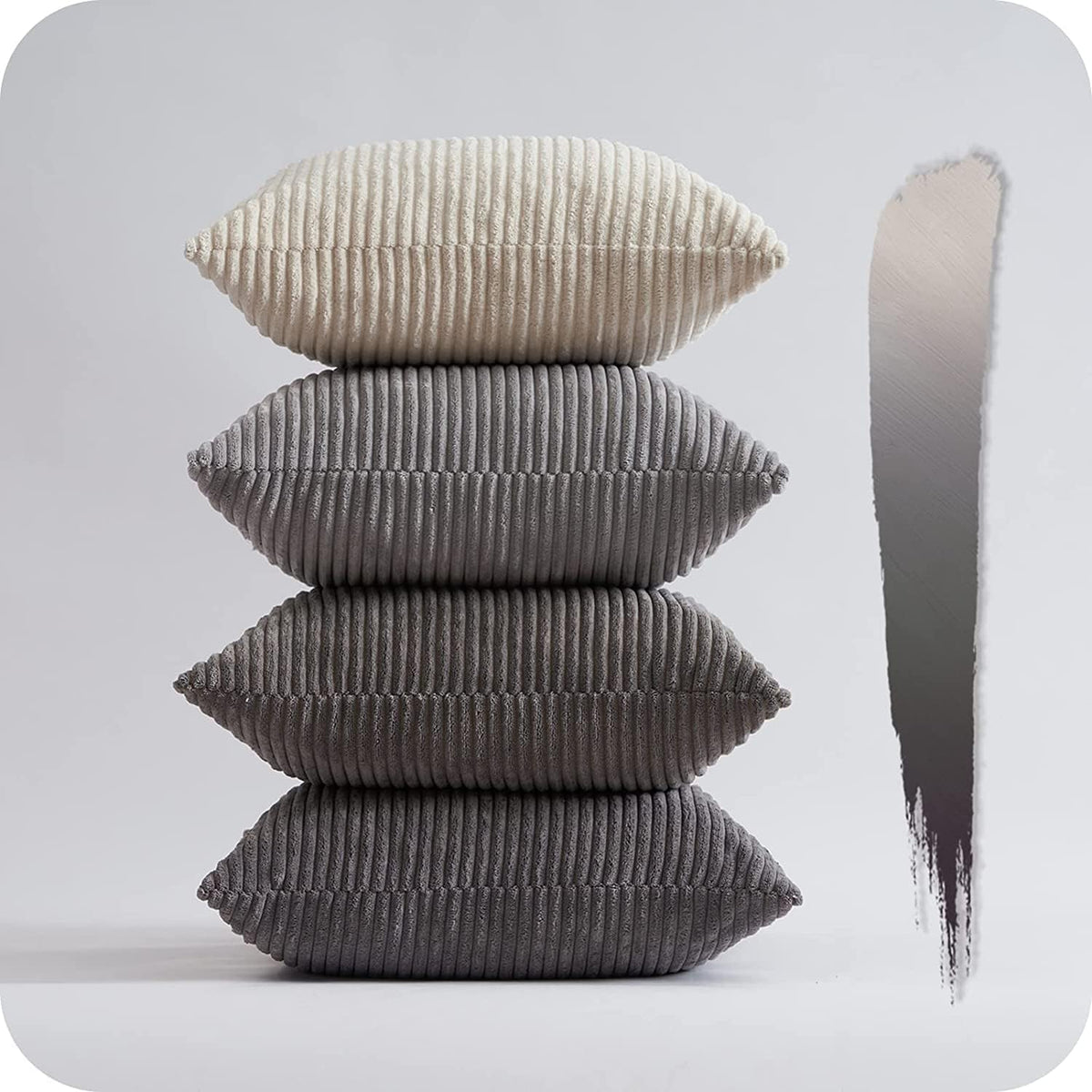 Vertical stack of four ribbed corduroy pillows in shades of gray on a reflective surface
