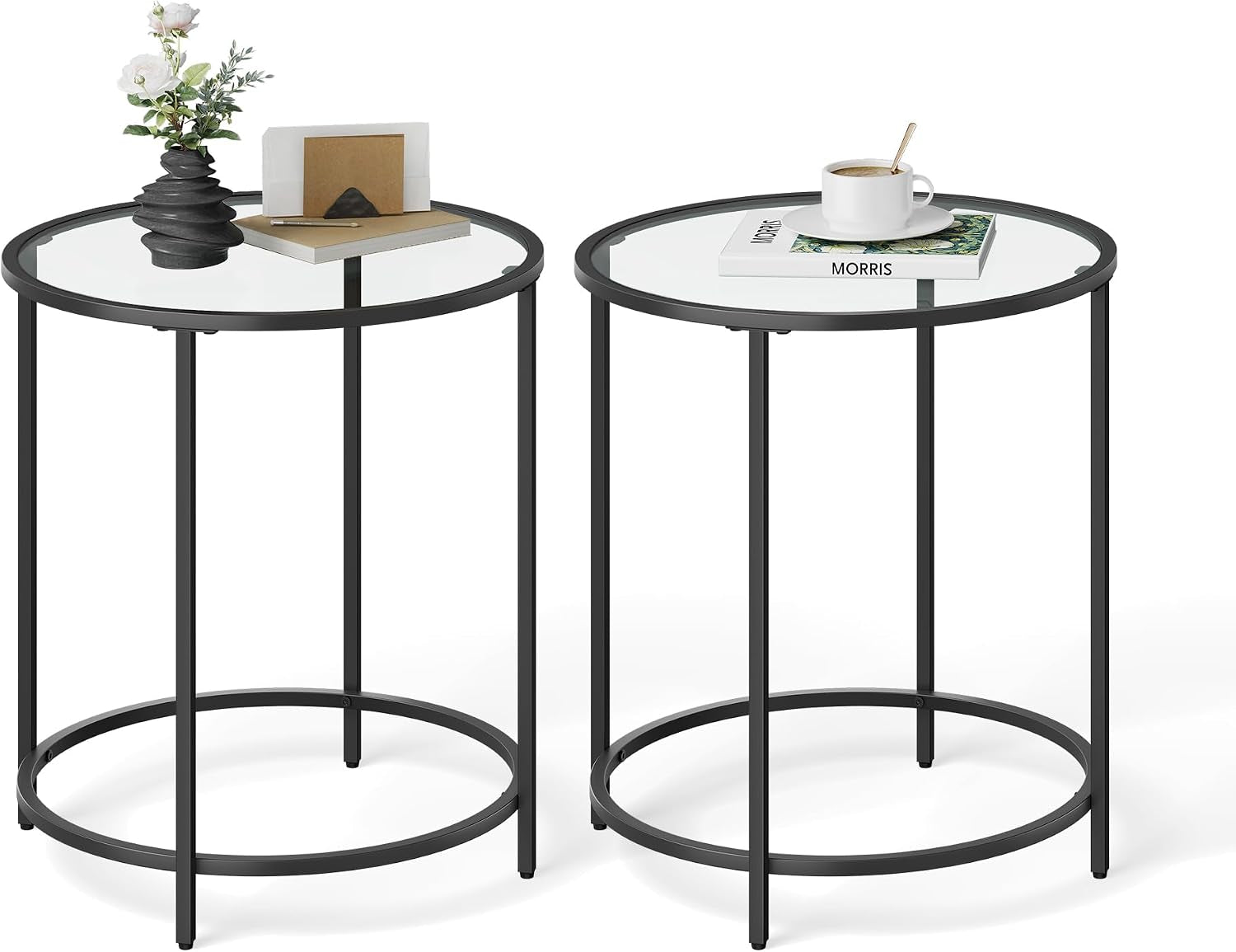Two black round glass-top side tables styled with a vase and a cup, shown on white background.