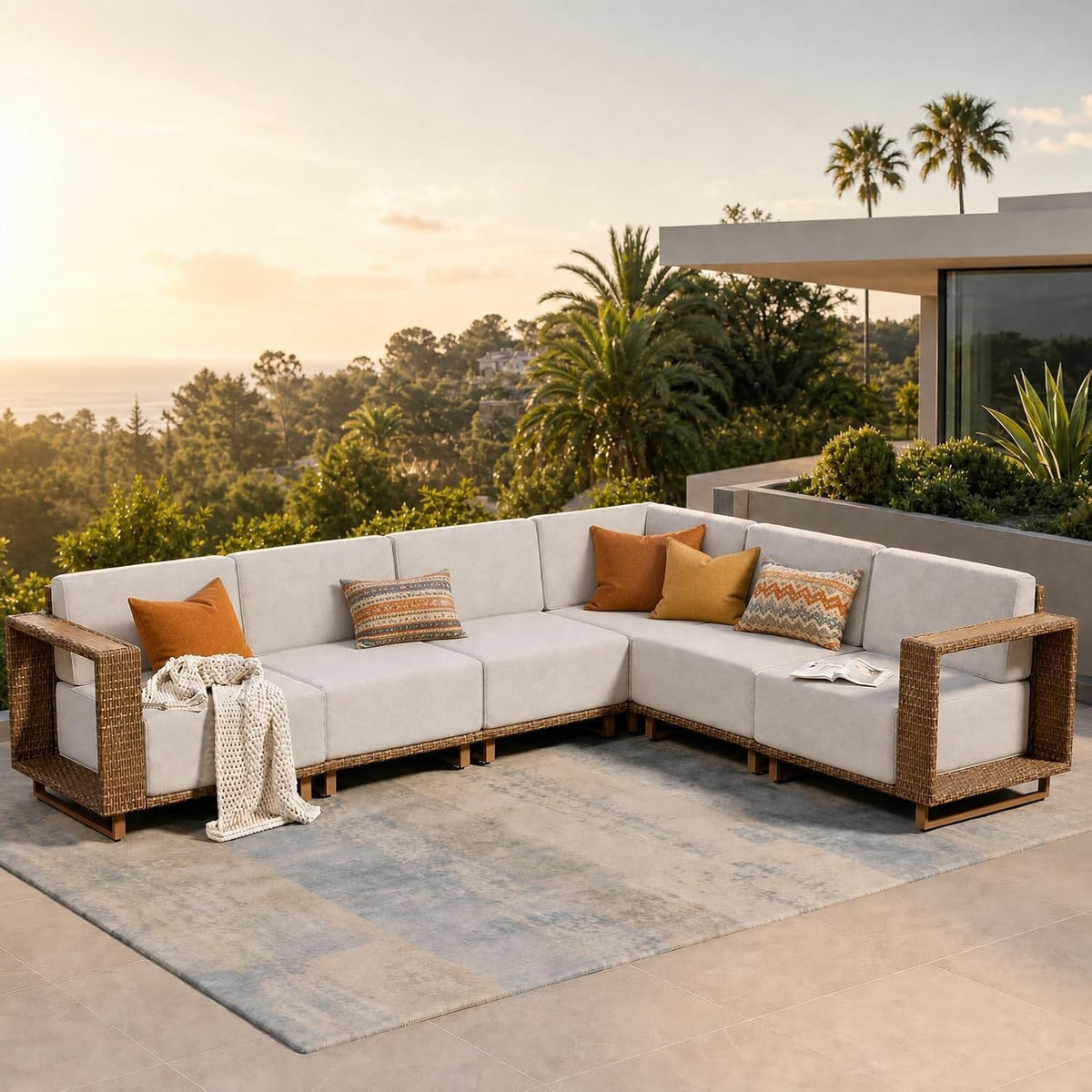 L-shaped sectional arranged on a patio with accent pillows and ocean view at sunset