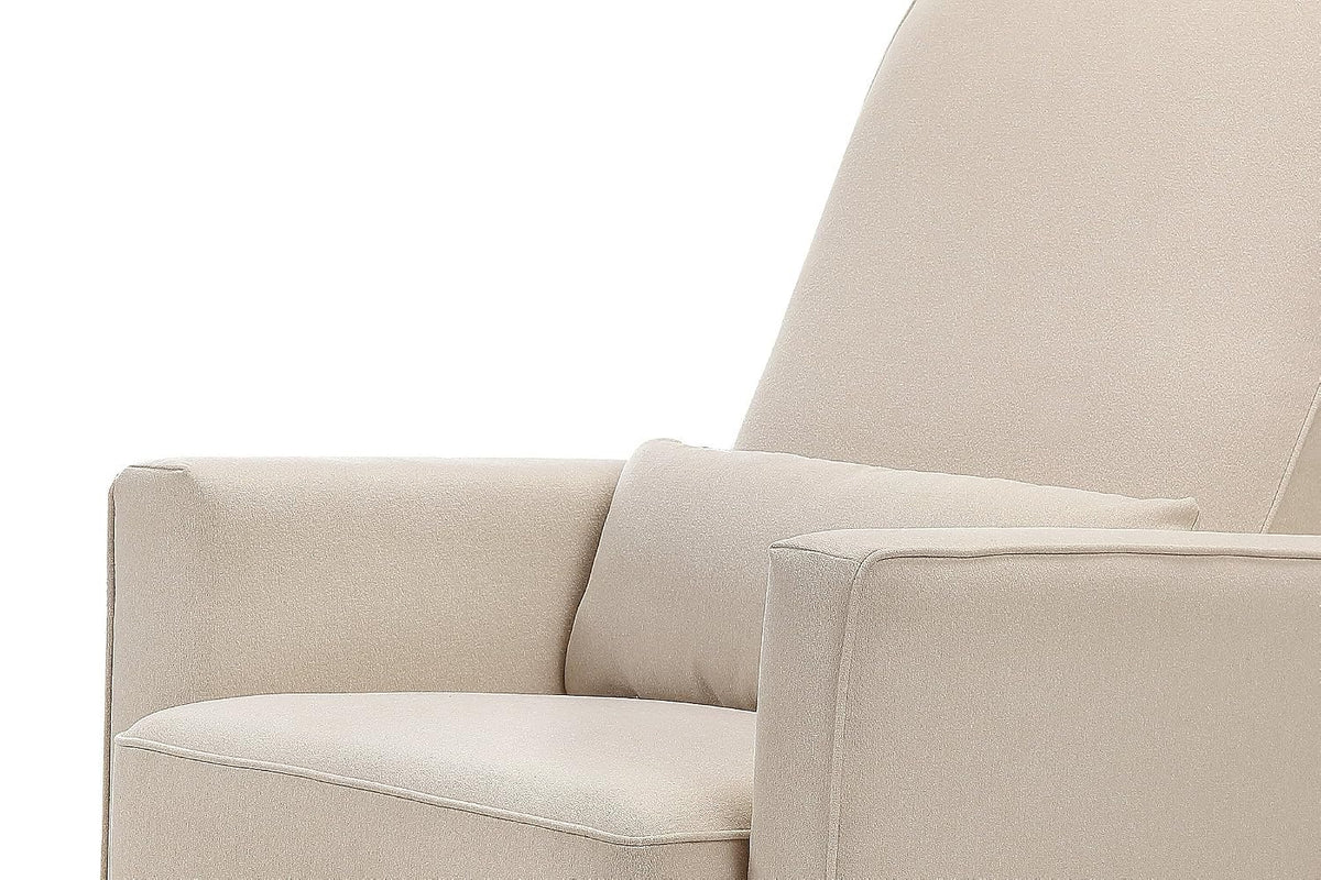 Close-up of cream upholstered glider showing seat cushion, narrow lumbar pillow, one armrest and part of the high back.