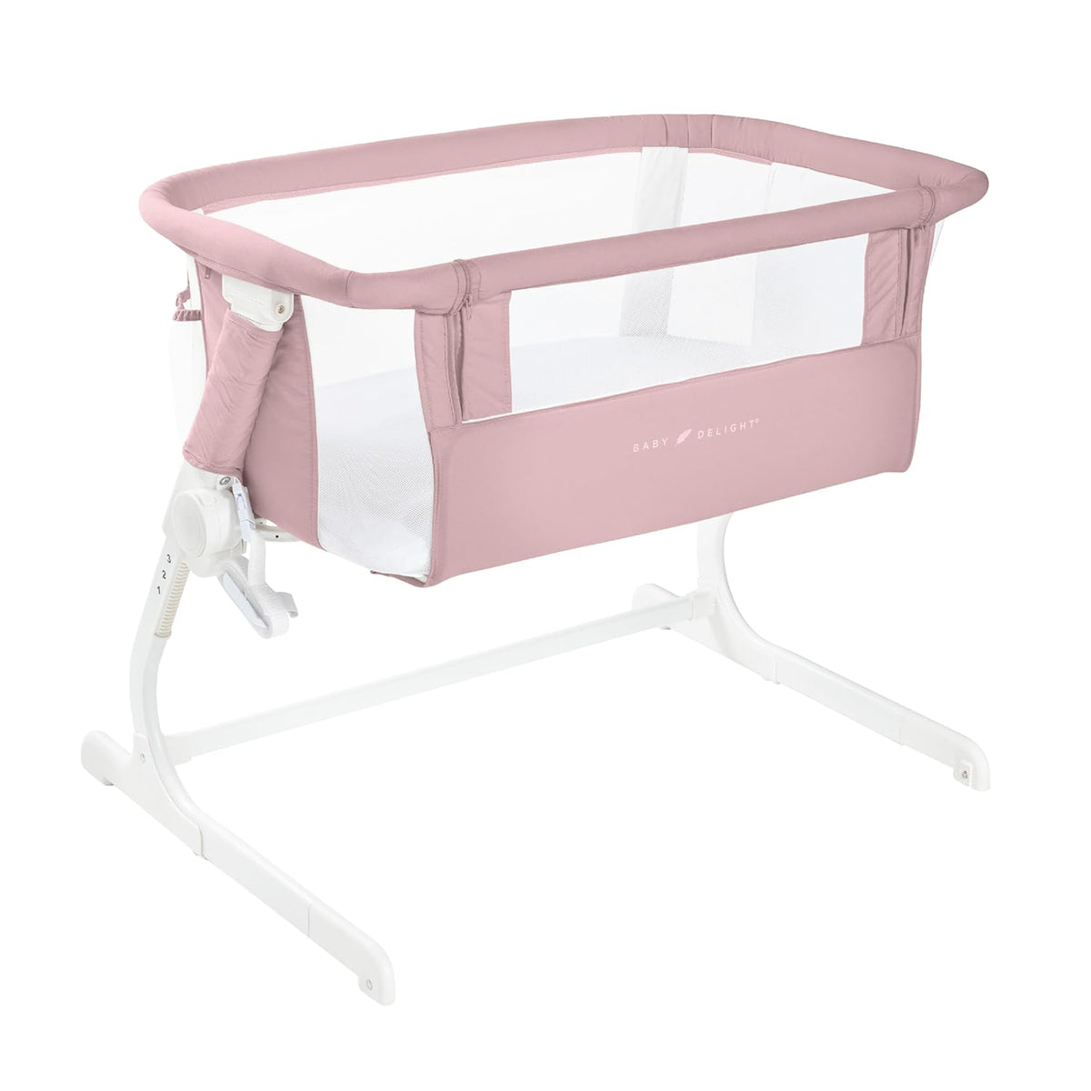 Light pink bedside bassinet with mesh side panels and white metal frame on a white background