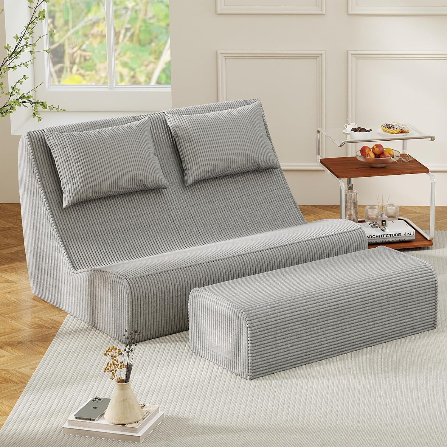 Two-seat version of the chaise with two back cushions, ottoman in front and a small wooden side table with fruit
