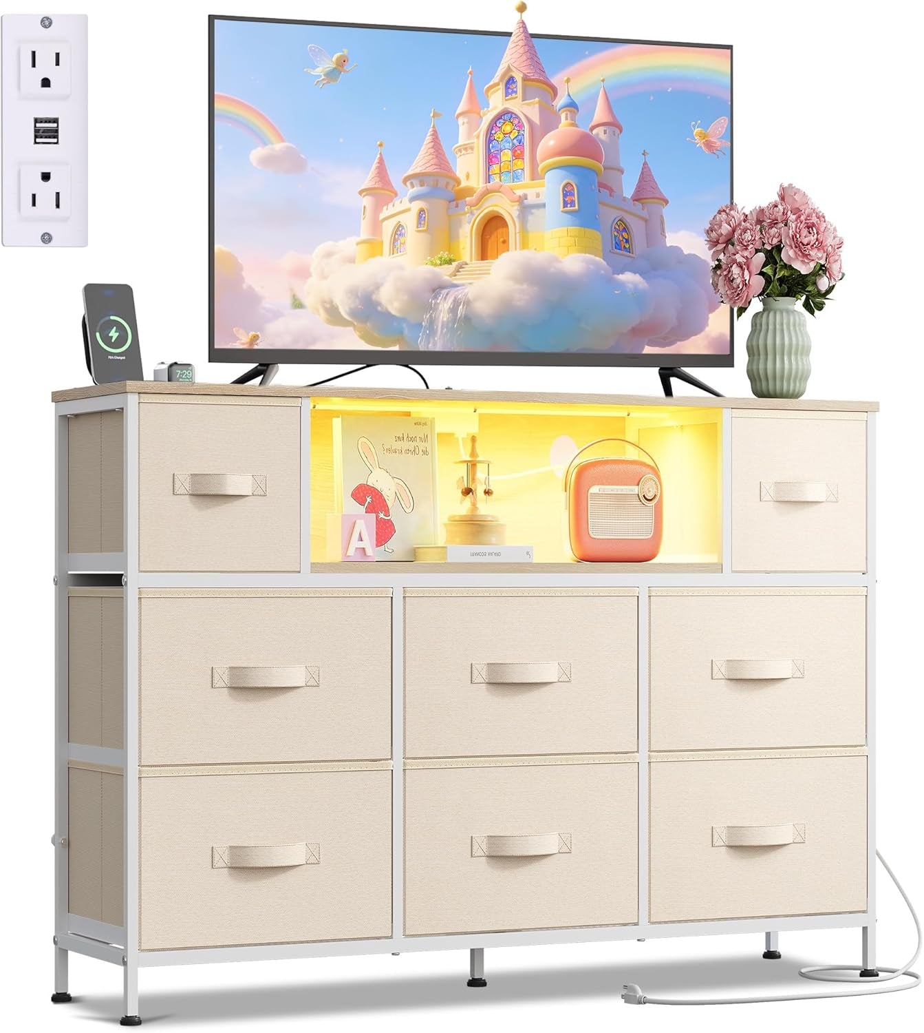 White-framed dresser with beige fabric drawers and lit center cubby holding small decor beneath a TV.