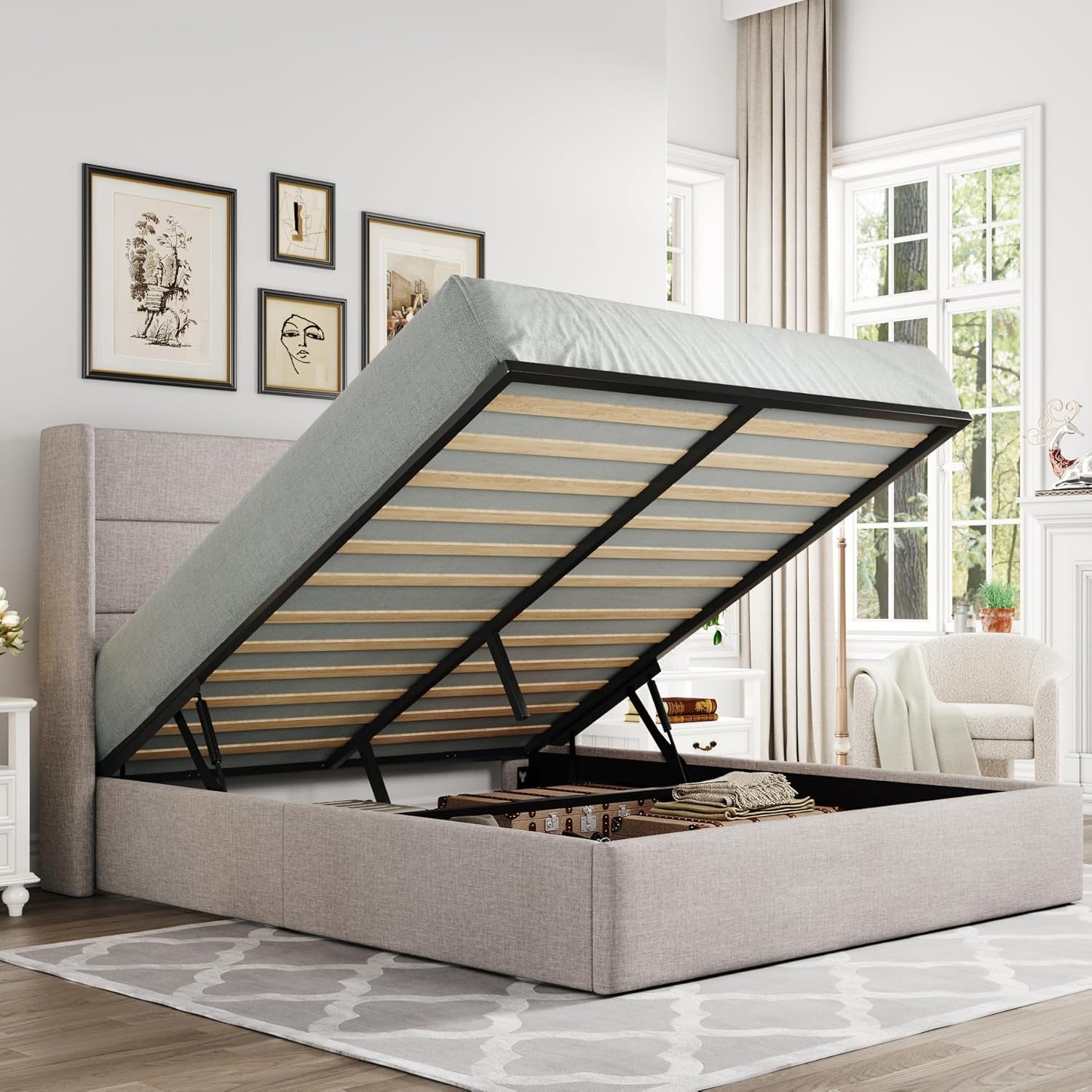 Angled bedroom view of an upholstered storage bed with the mattress lifted to show open under-bed storage.