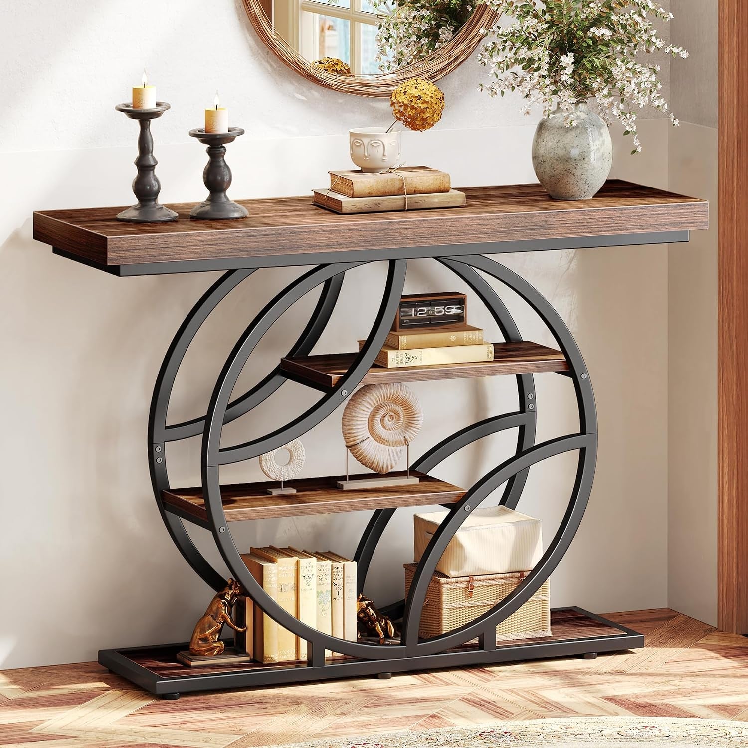 Close detail of the console's circular black metal frame and three wood shelves with decorative books and boxes.