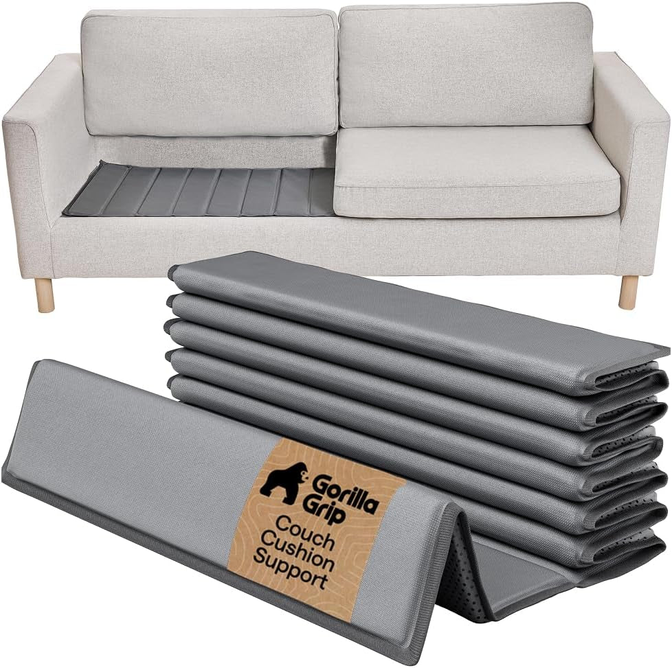 Grey folded support panels stacked in front of a sofa with one board installed under left seat cushion