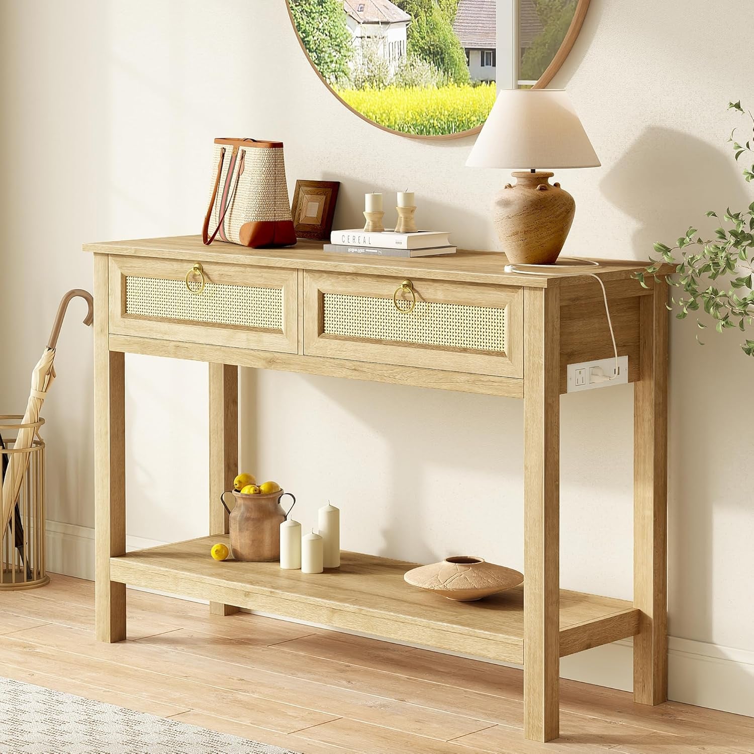 Three-quarter view of the light oak console with a lamp and round mirror, lamp cord draped on the top