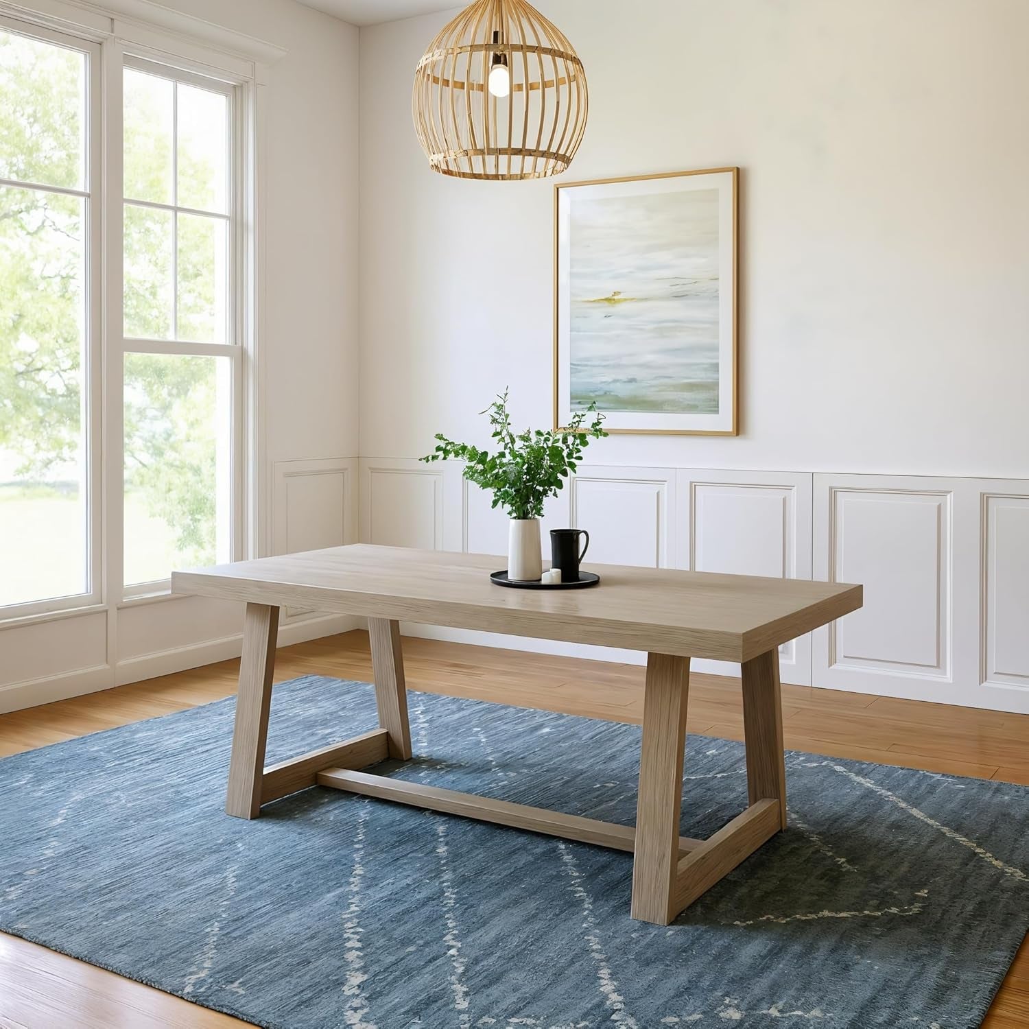 Pecan-finished dining table centered on a blue rug under a woven pendant light.