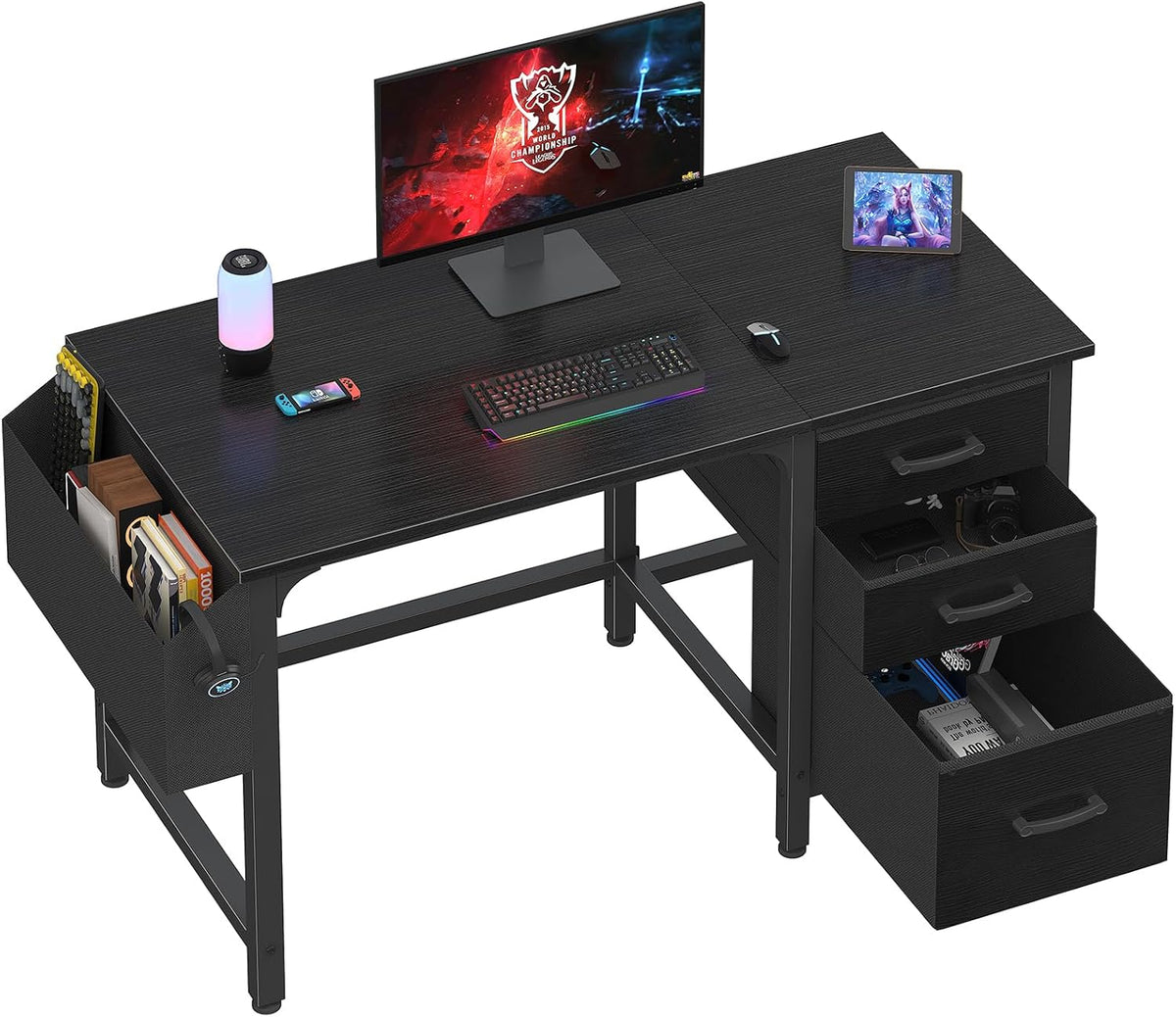 Black L-shaped desk with fabric file pocket on left and three fabric drawers on right, styled with monitor and keyboard.