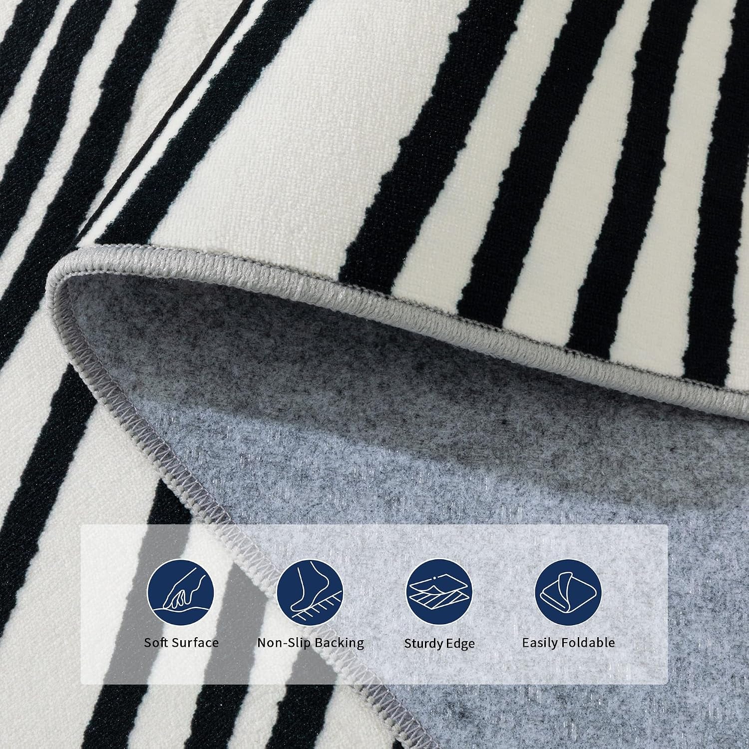 Close-up of rug corner folded to show gray non-slip backing and stitched edge with black abstract lines.