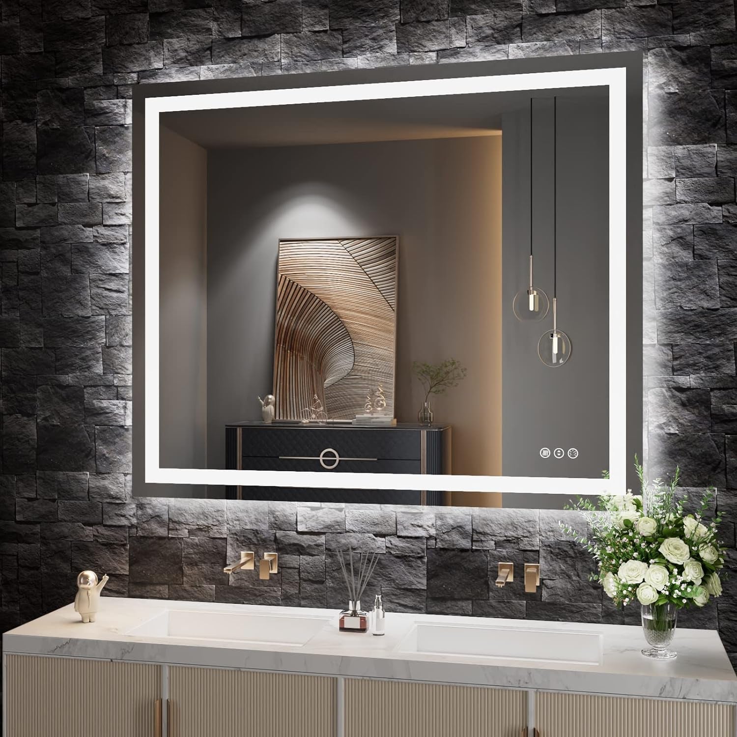 LED mirror mounted on dark stone wall with backlight, reflecting artwork and pendant lights above vanity