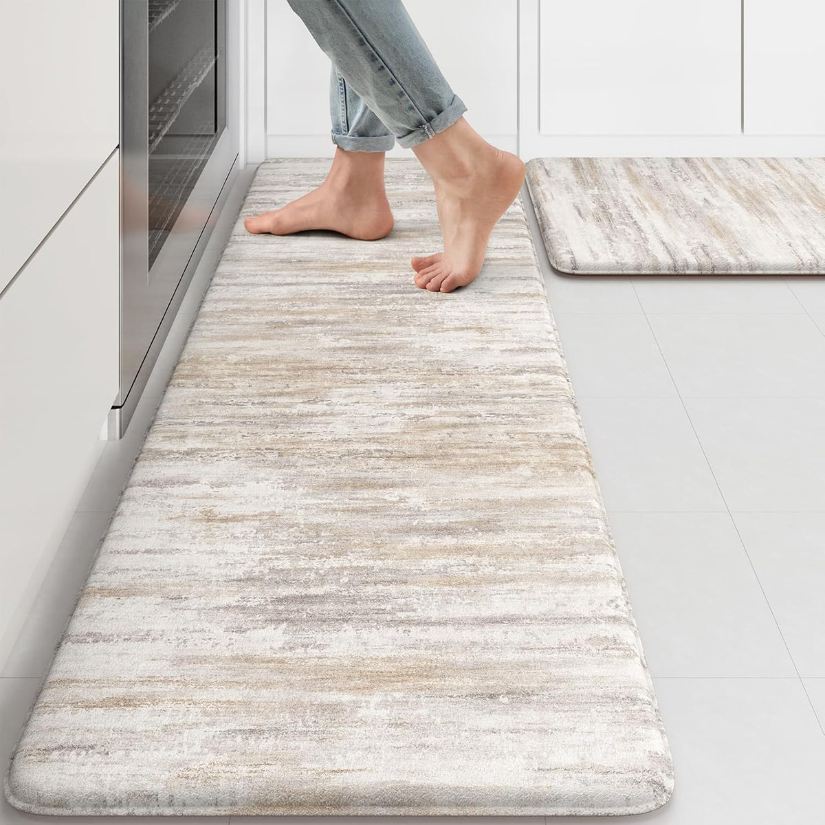 Long textured beige-gray runner mat on a kitchen floor with bare feet standing on it