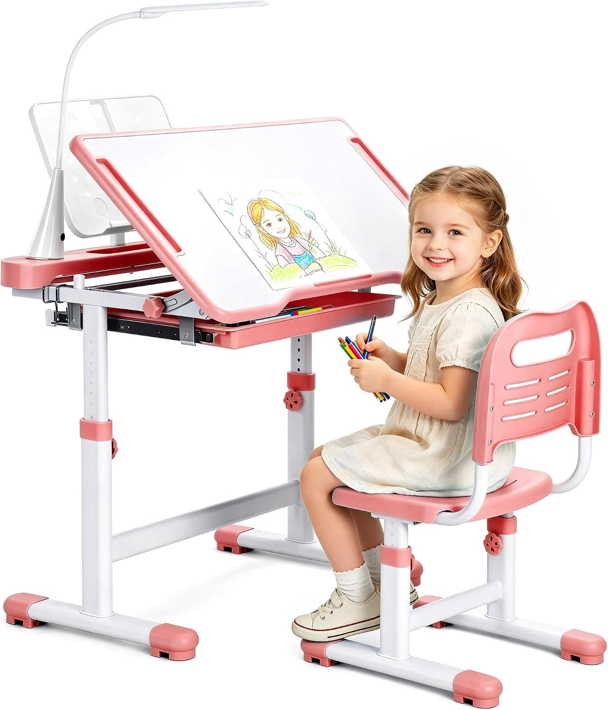 Pink adjustable kids desk and matching chair with a smiling young girl sitting and holding colored pencils, desktop tilted.