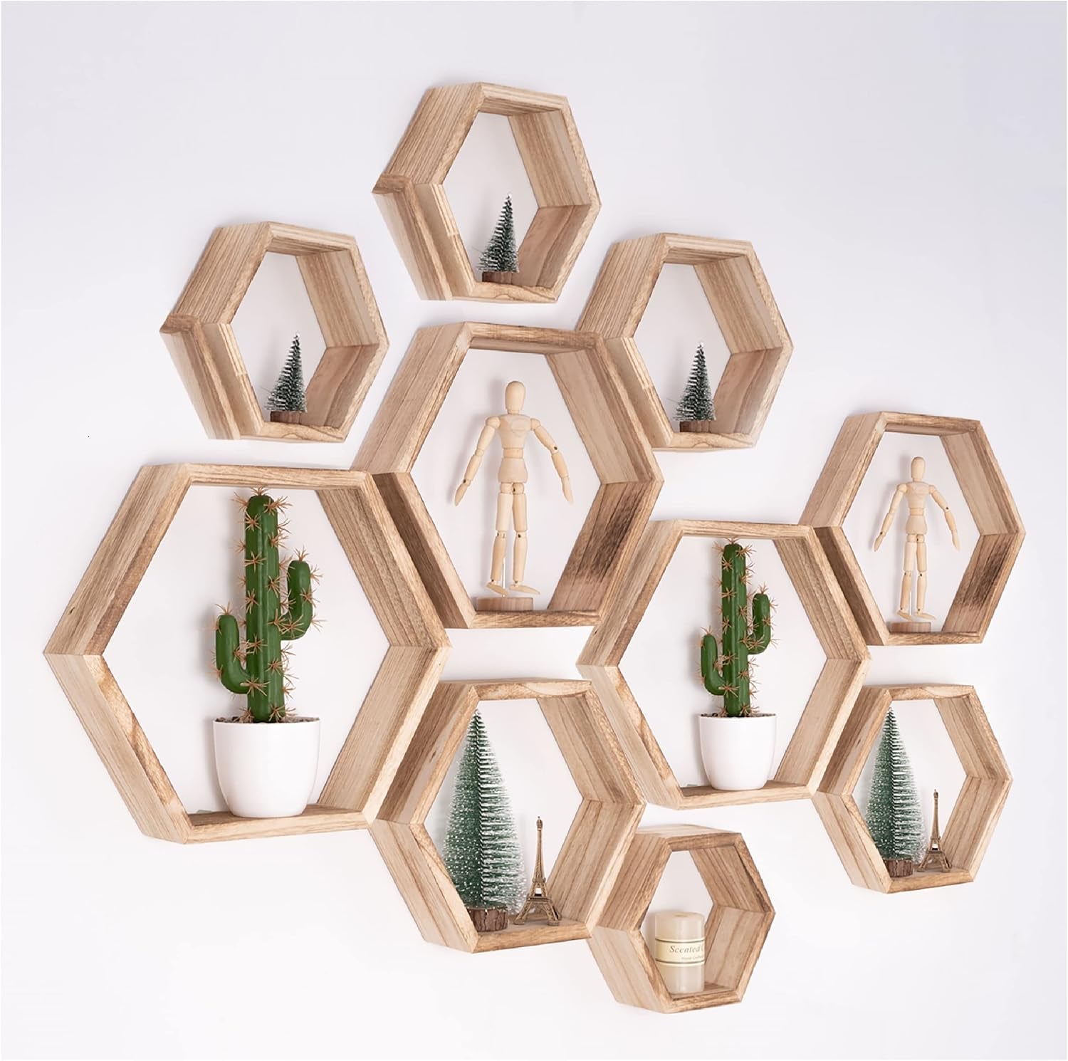 Light driftwood hexagon shelf set arranged on a white wall with plants and small figures.