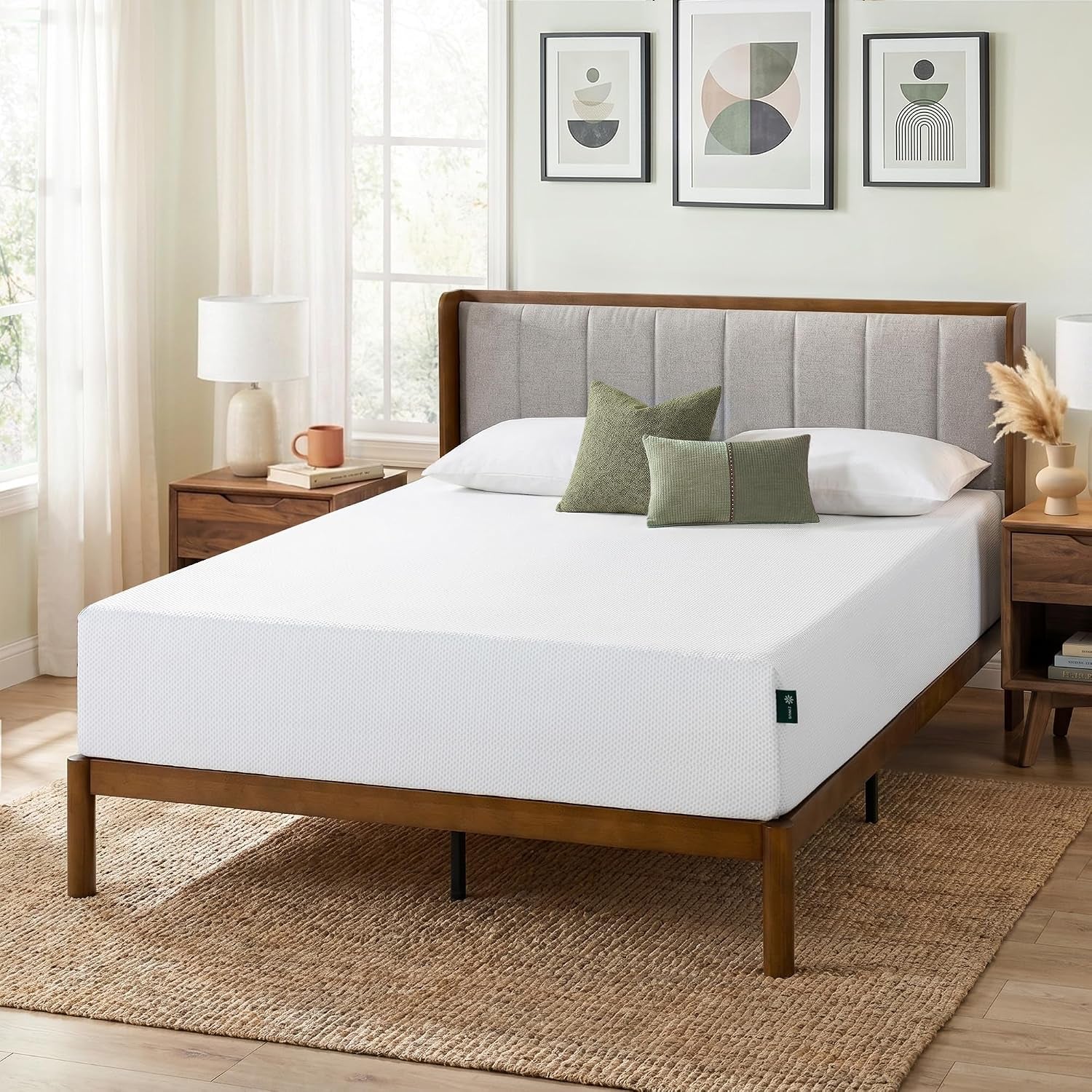 Slightly closer view of the mattress on the wooden bed frame showing bed linens, green accent pillows, and bedside decor.