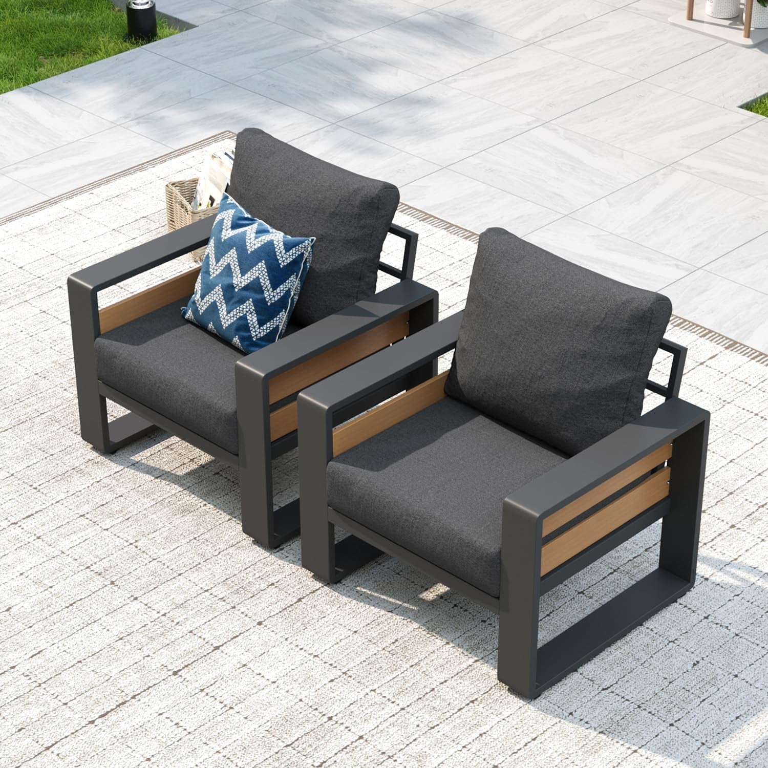 Close-up of two armchairs with charcoal metal frames, wood-accent slats and dark gray seat and back cushions.