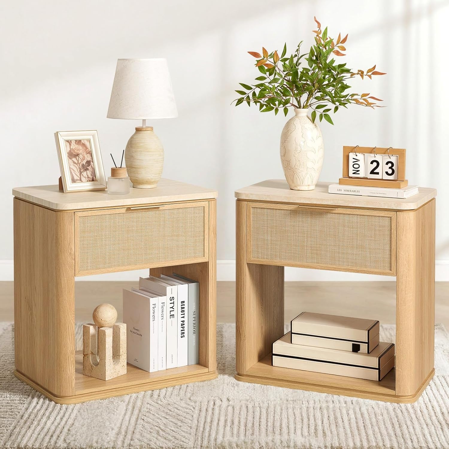 Two light oak nightstands with open lower shelf and a single upper drawer, styled with books and decor.