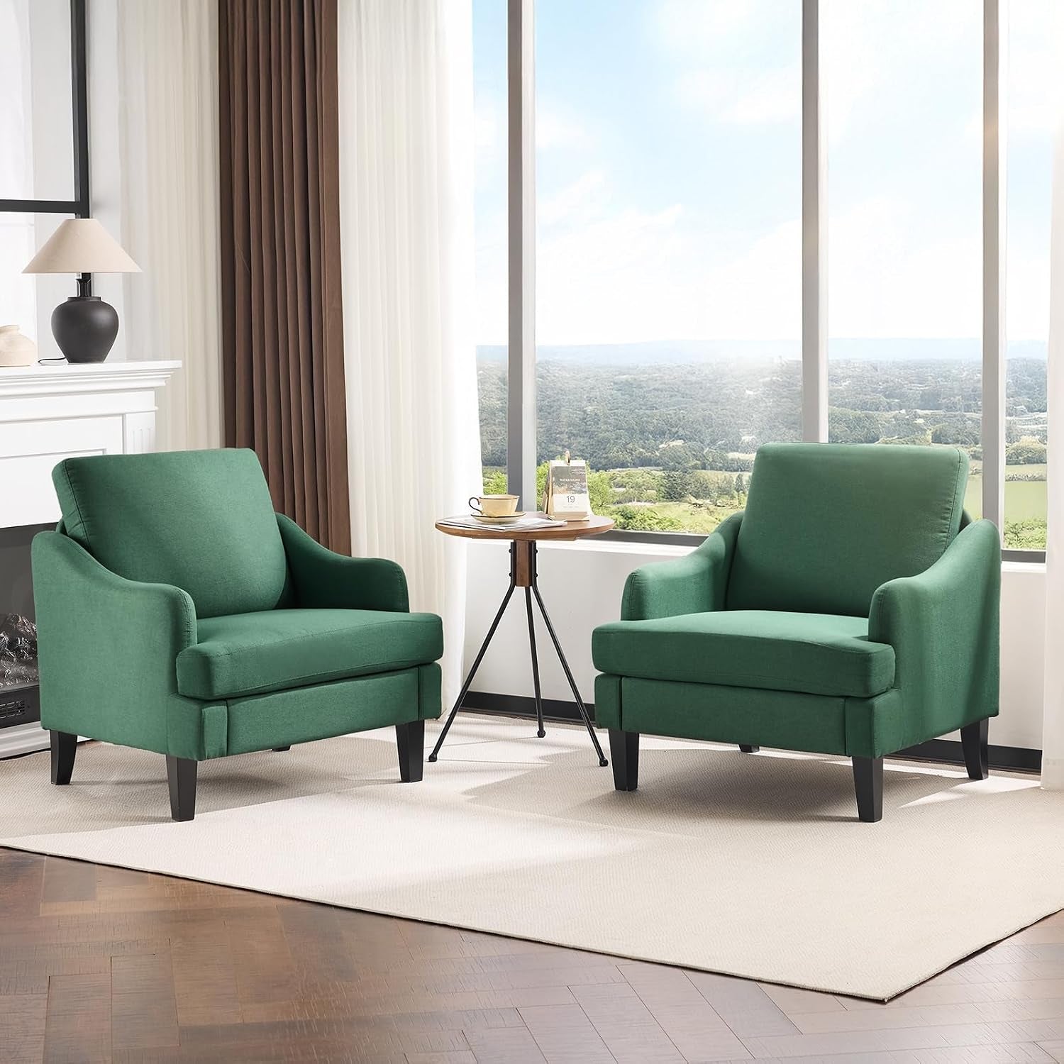 Two matching deep green armchairs facing slightly inward with a small round table between them.
