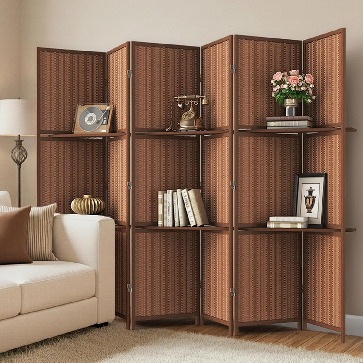 Angled view of darker bamboo four-panel divider with small shelves and decorative objects beside a sofa