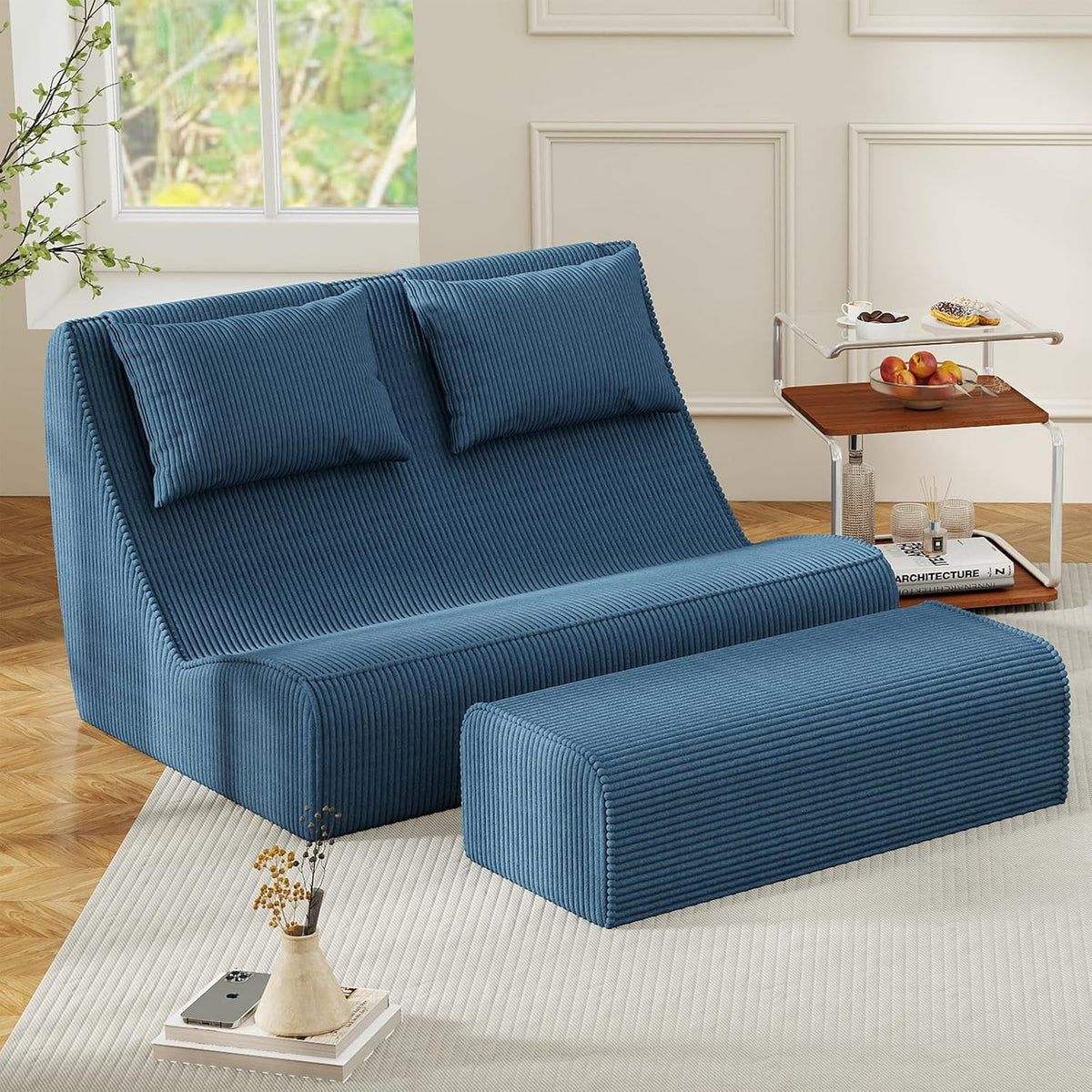 Teal-blue chaise lounge with matching ottoman shown in a softly lit living space next to a small side table.