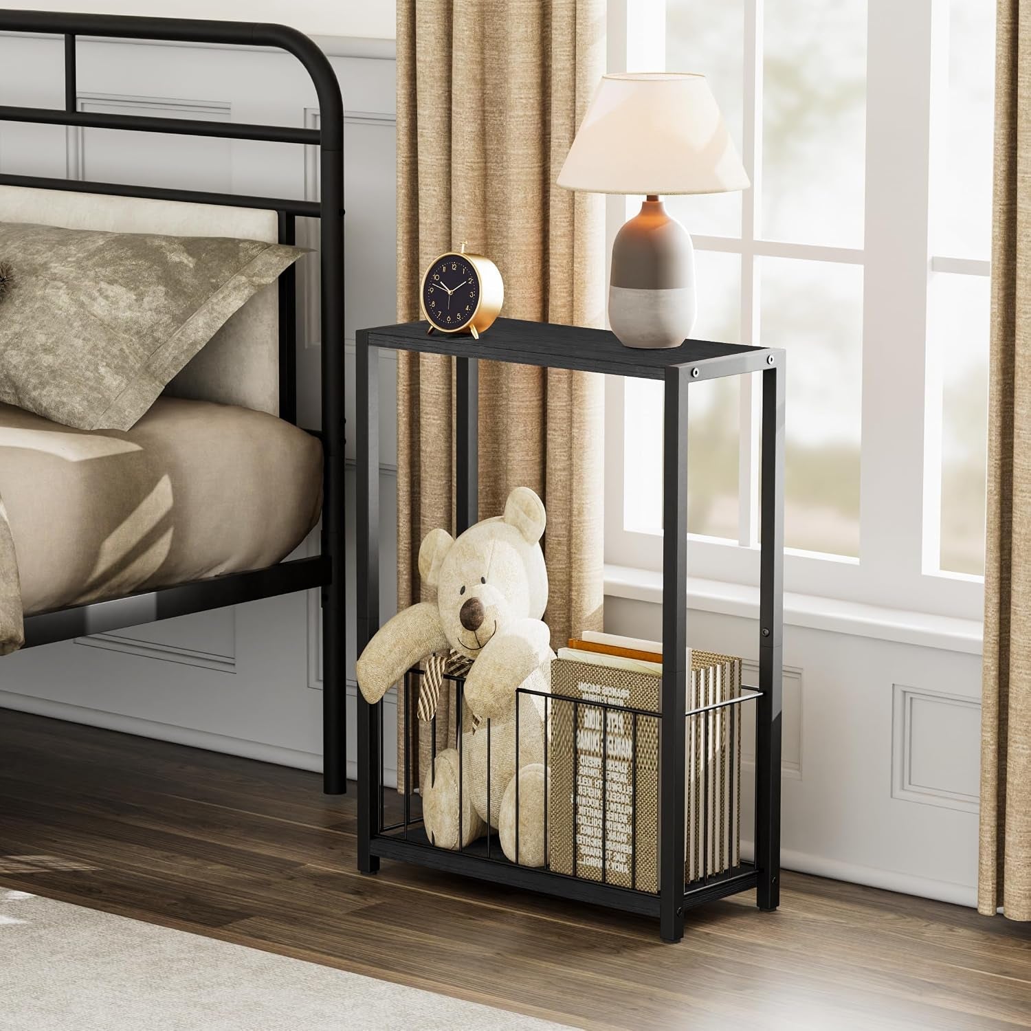 Side table placed by a window and bed, showing stuffed bear and books stored in the lower wire basket beneath the tabletop.